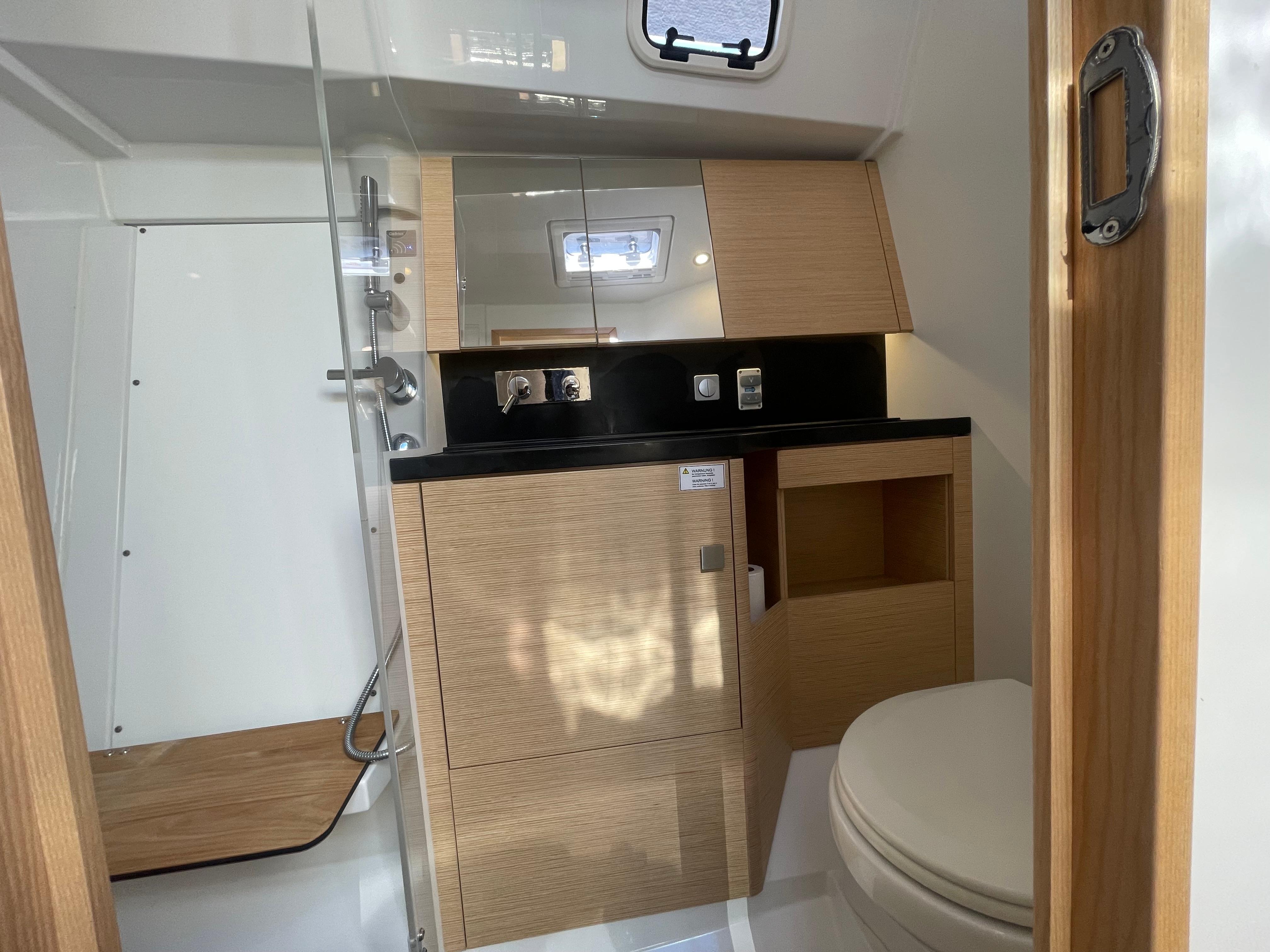 Modern bathroom interior of 2024 Hanse 410 yacht with wood accents and sleek fixtures.