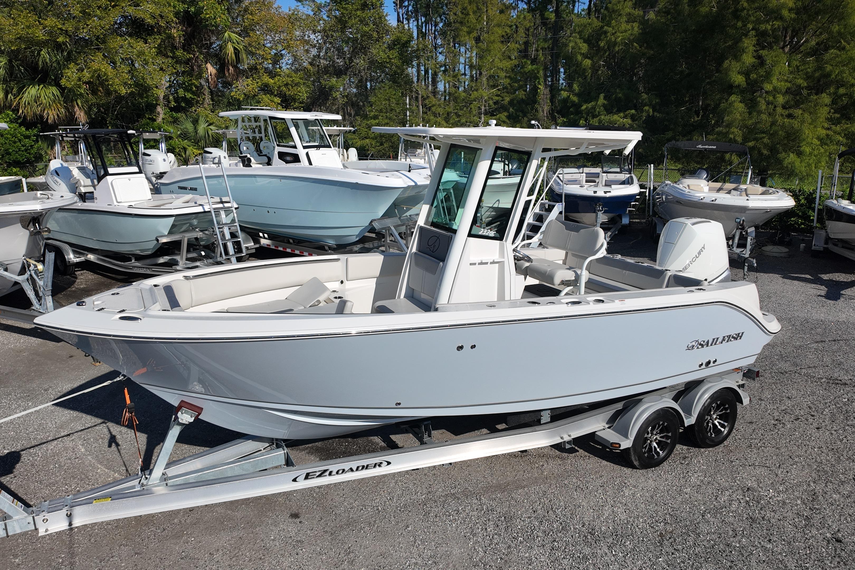 2026 Sailfish 232 CC boat on trailer, surrounded by trees and other boats.