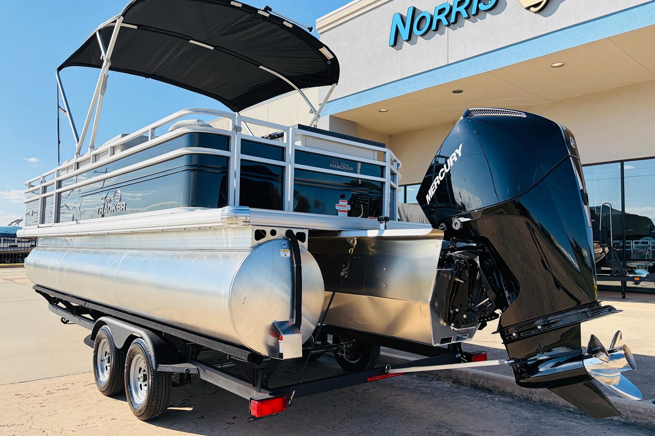 2026 Sun Tracker Fishin' Barge 22 XP3 pontoon boat with Mercury engine, parked outside dealership.