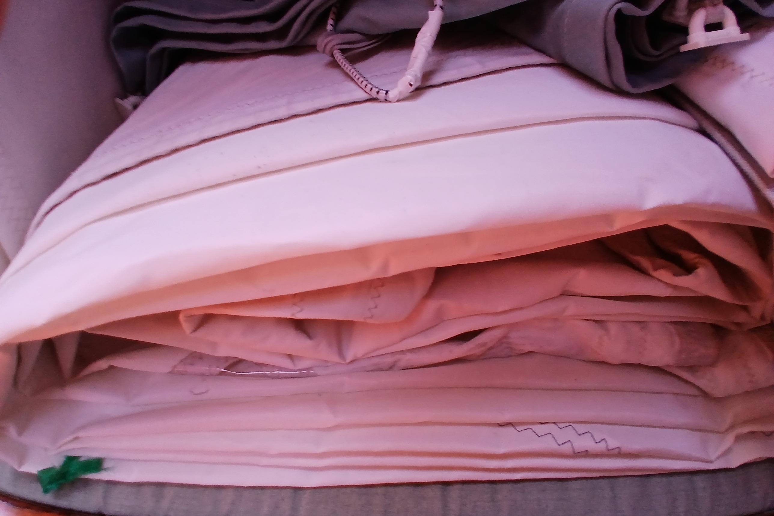 Folded sails stored neatly, possibly from a 1981 Kaufman Skye 51 yacht.