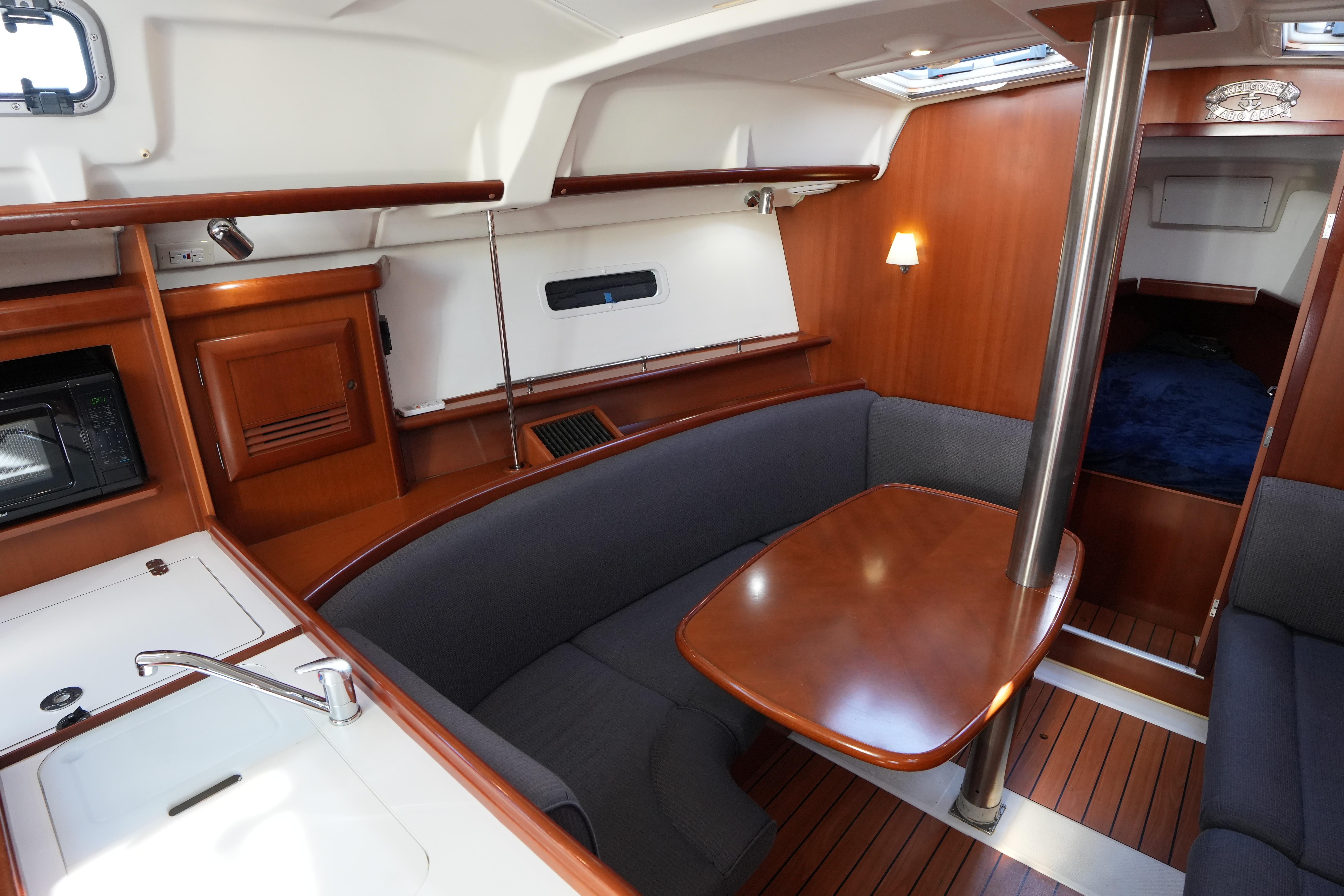 Interior of 2007 Beneteau 373 sailboat with wood finish and cozy seating area.