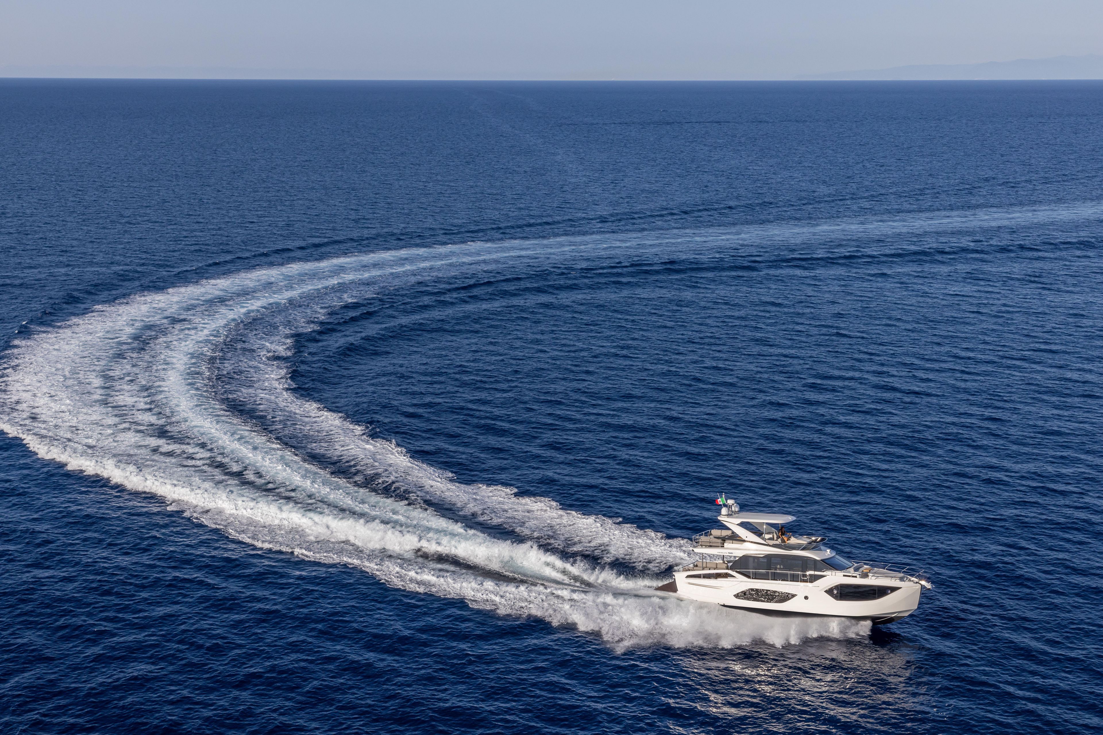 2025 Absolute 56 FLY yacht cruising on open sea, creating a dynamic water trail.