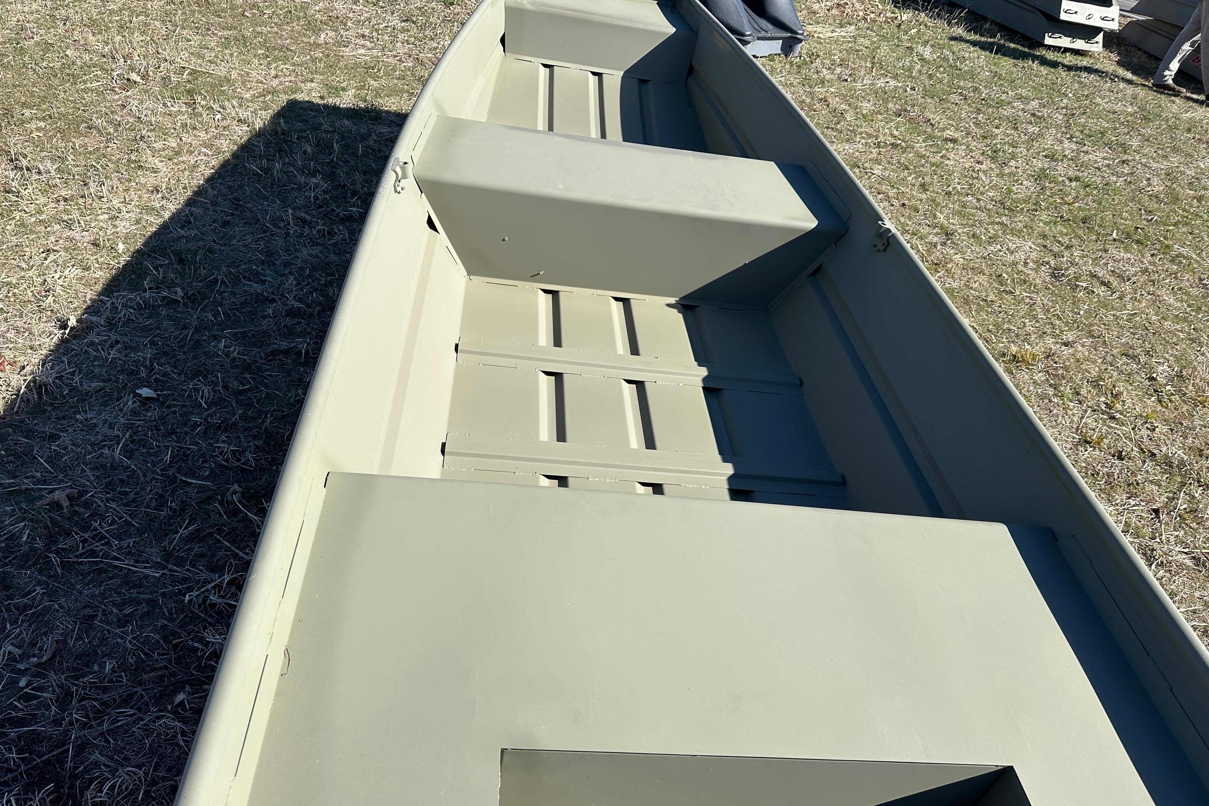 2026 Tracker Grizzly 14 Jon boat on grass, showcasing interior seating and structure.