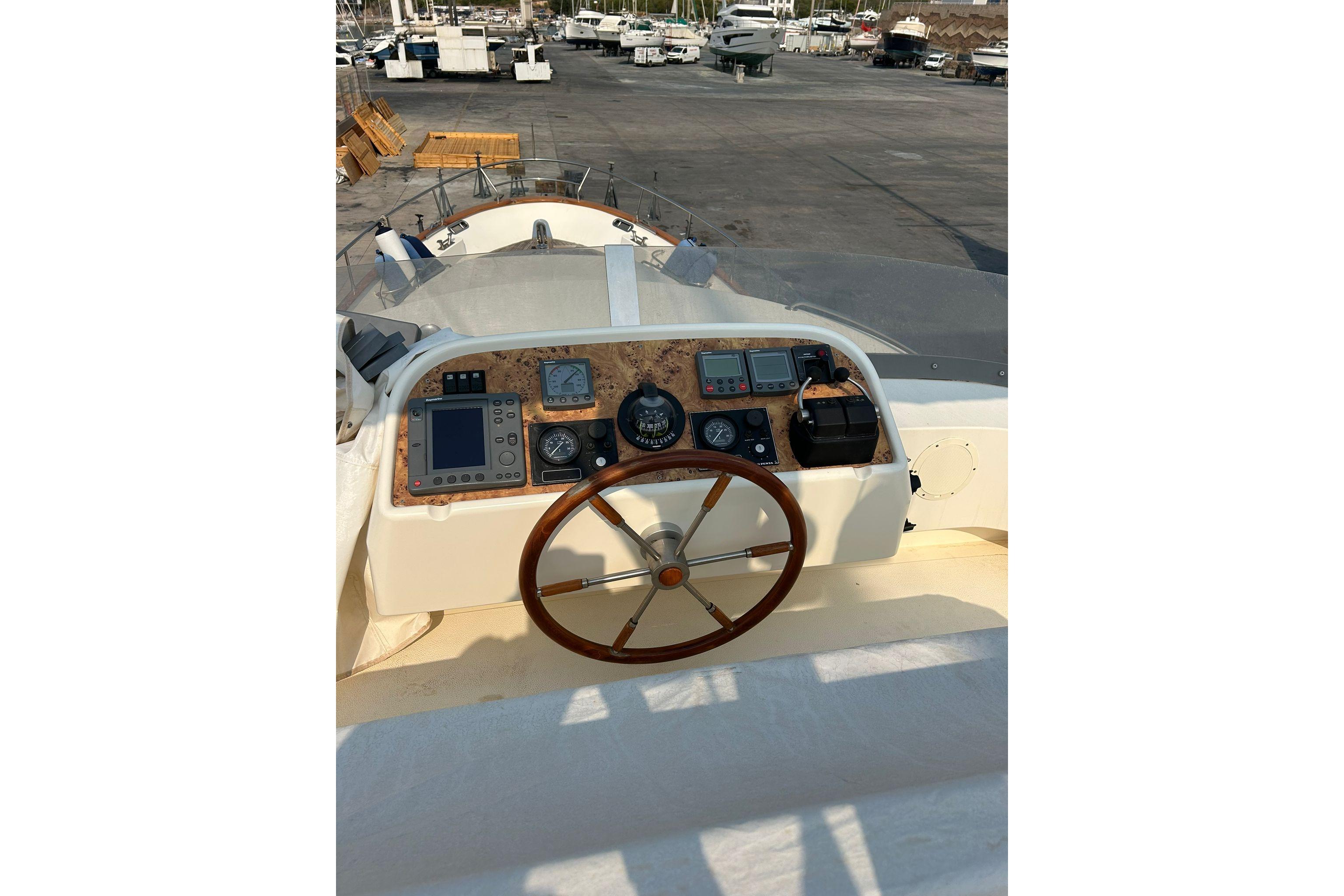 Helm of 2001 Belliure 40 yacht with wooden steering wheel and navigation instruments.