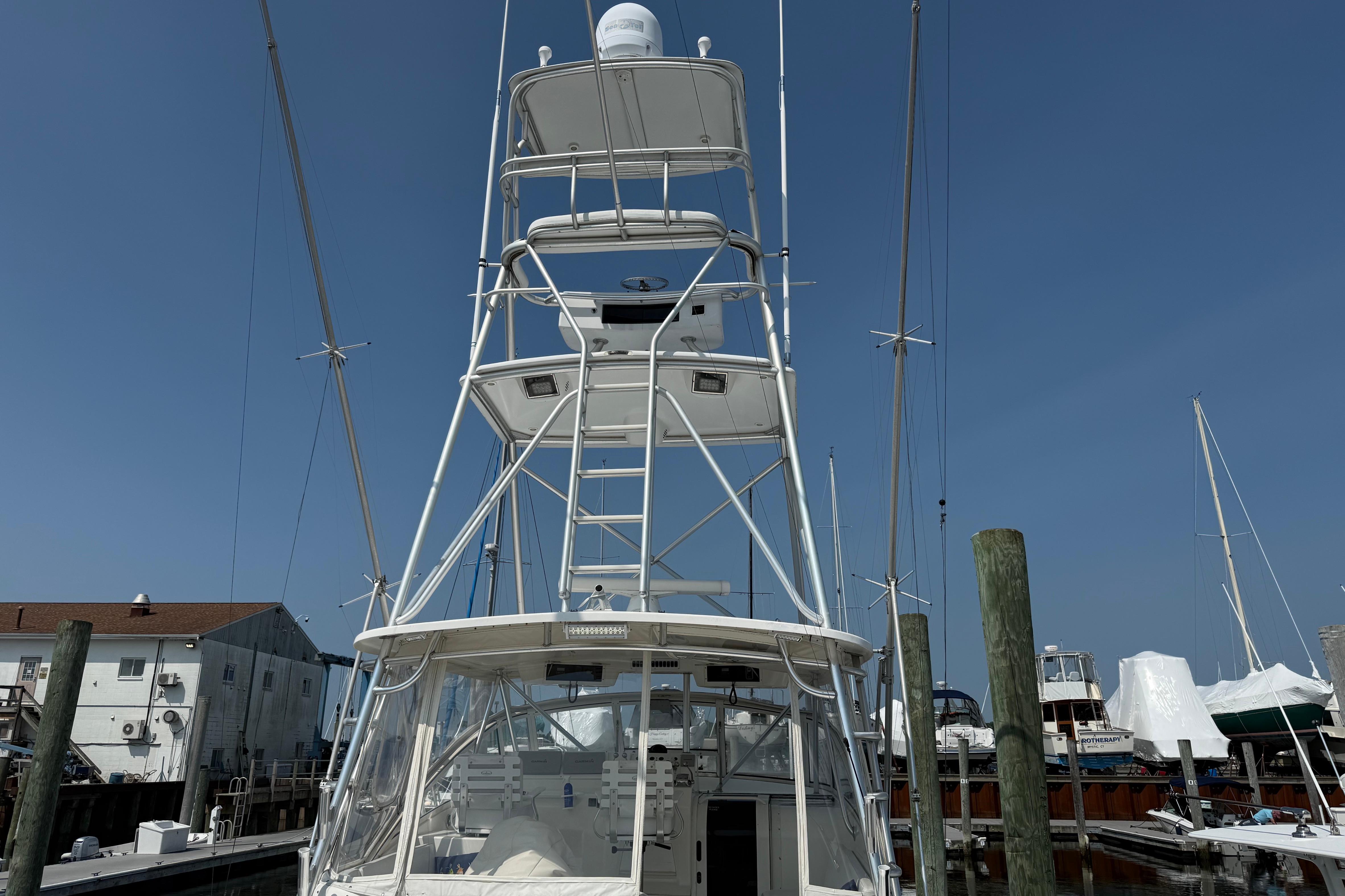 1999 Ocean Yachts 40 Express boat docked at marina under clear blue sky.