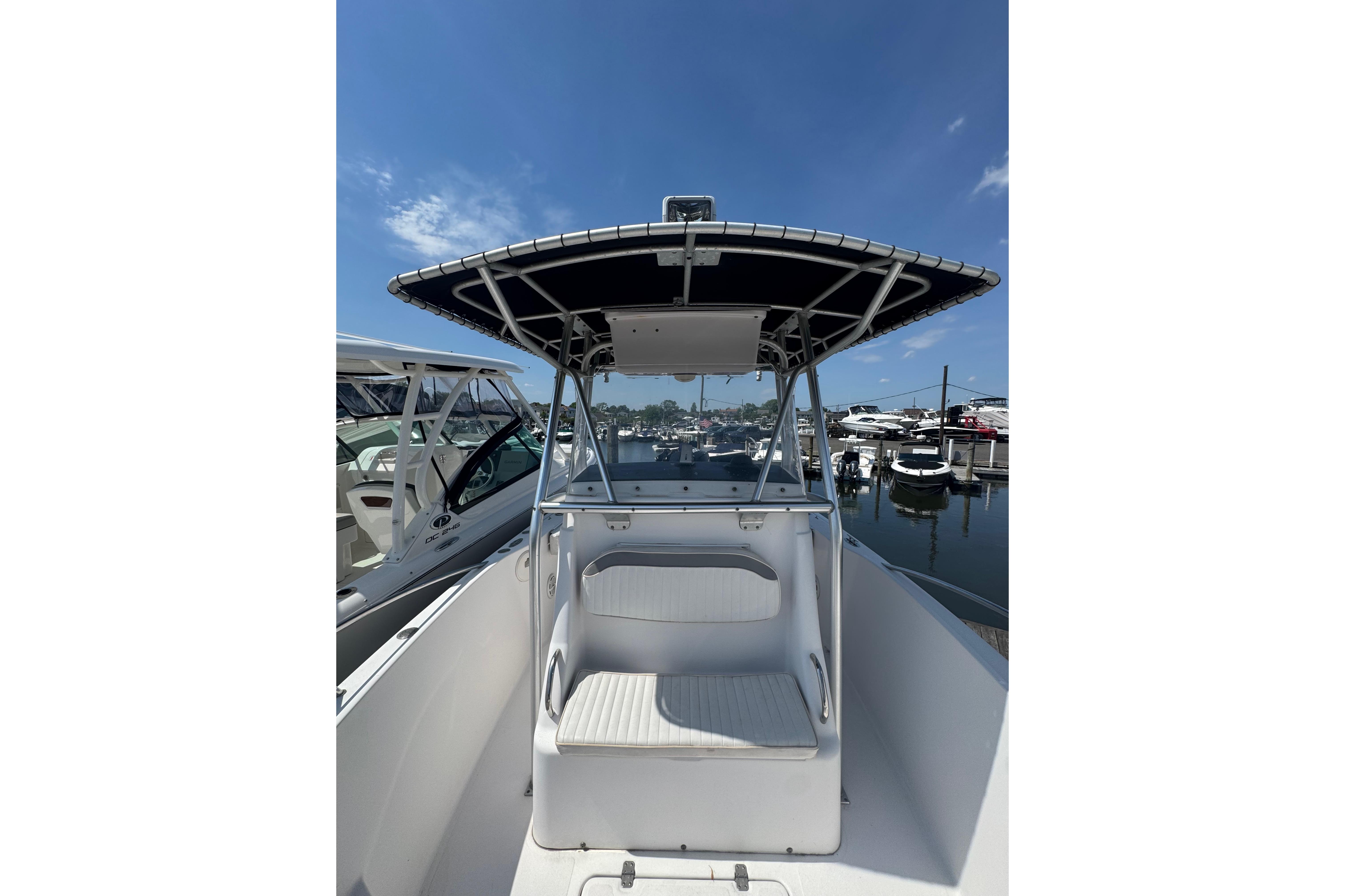2002 Pro-Line 23 Sport boat docked at marina under clear blue sky.