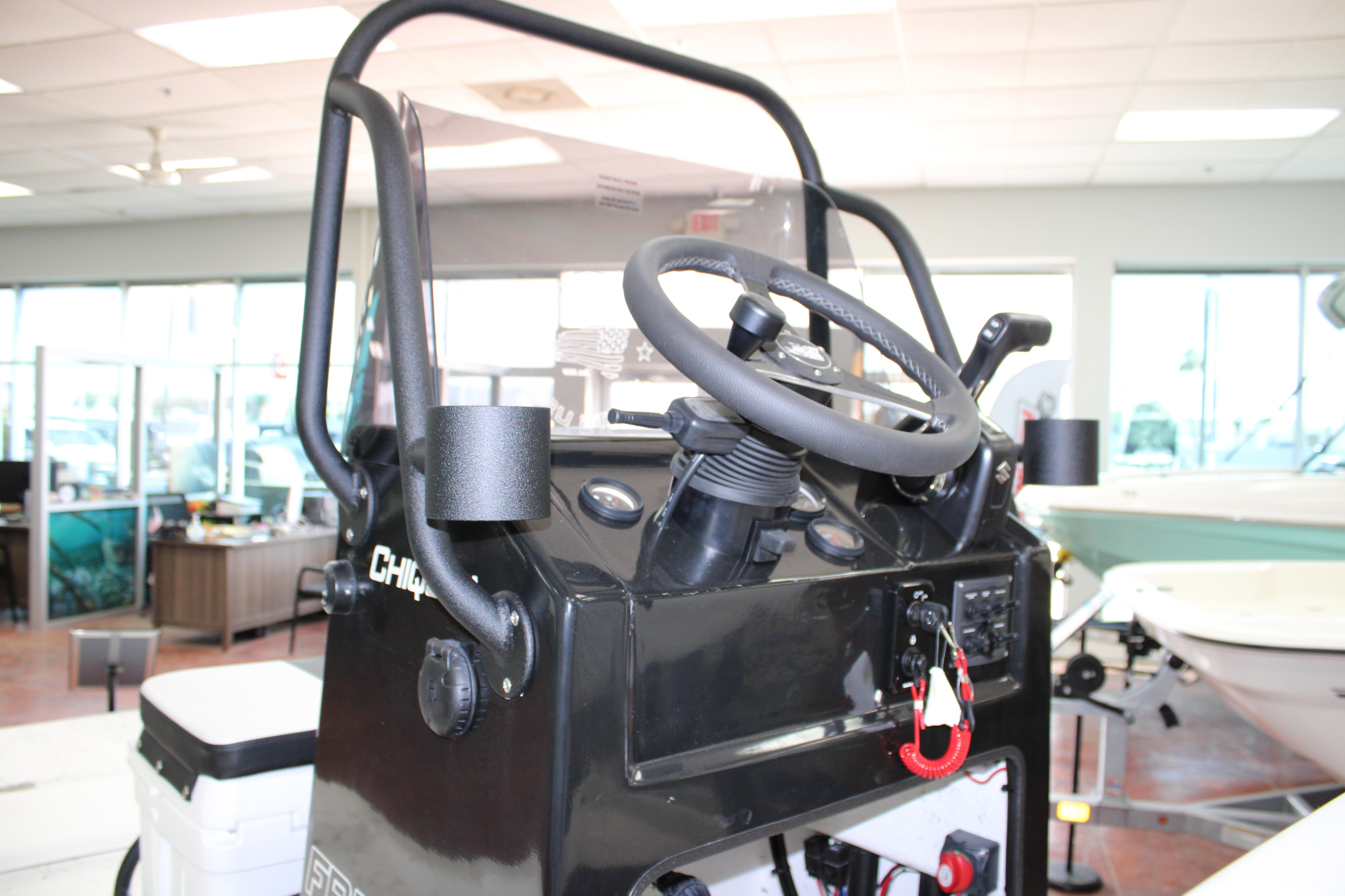 2026 Freedom Boats Chiquita steering console in showroom, featuring modern controls and design.