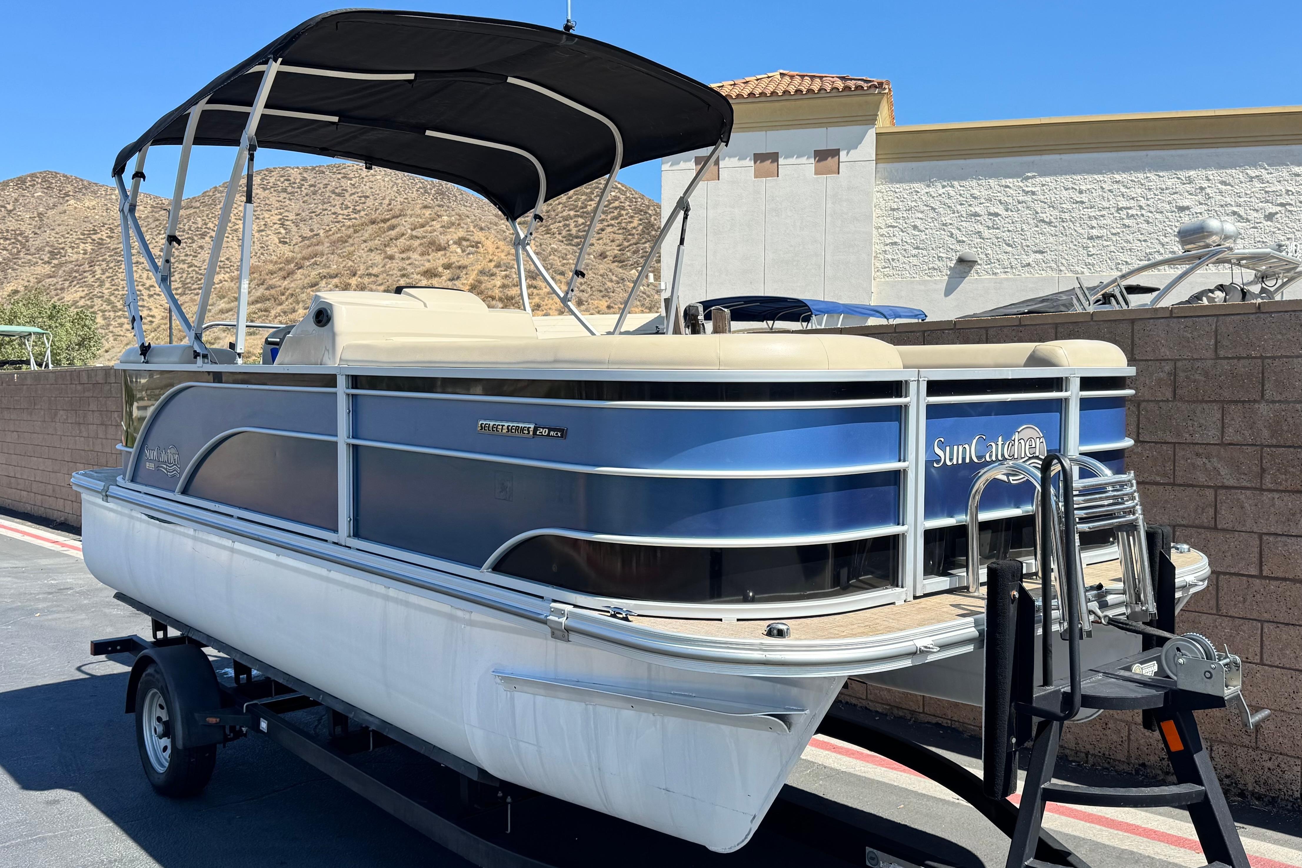 2021 SunCatcher Select 20RCX pontoon boat on trailer, parked outdoors.