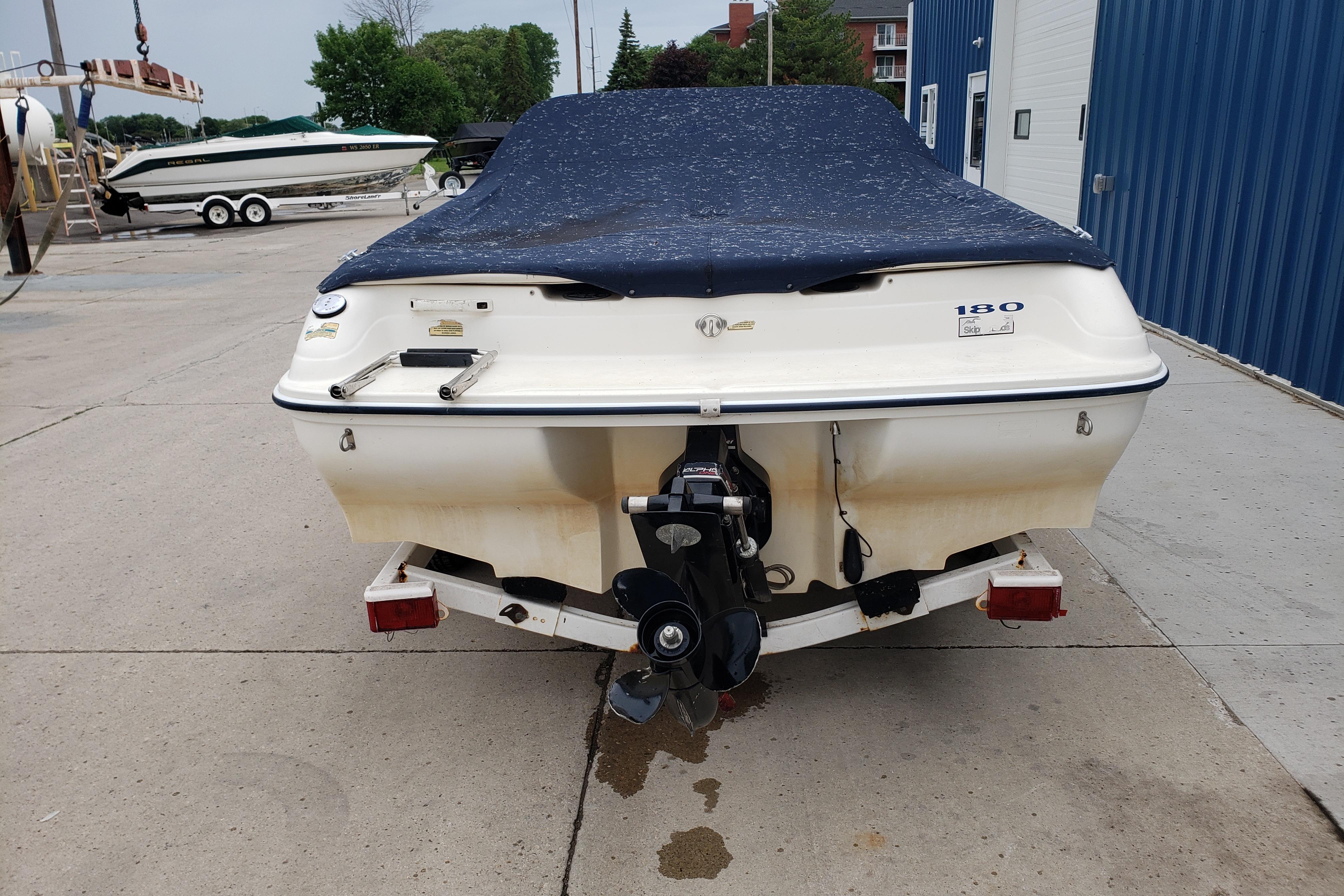 1998 Sea Ray 180 Bow Rider boat with cover, parked on a trailer.