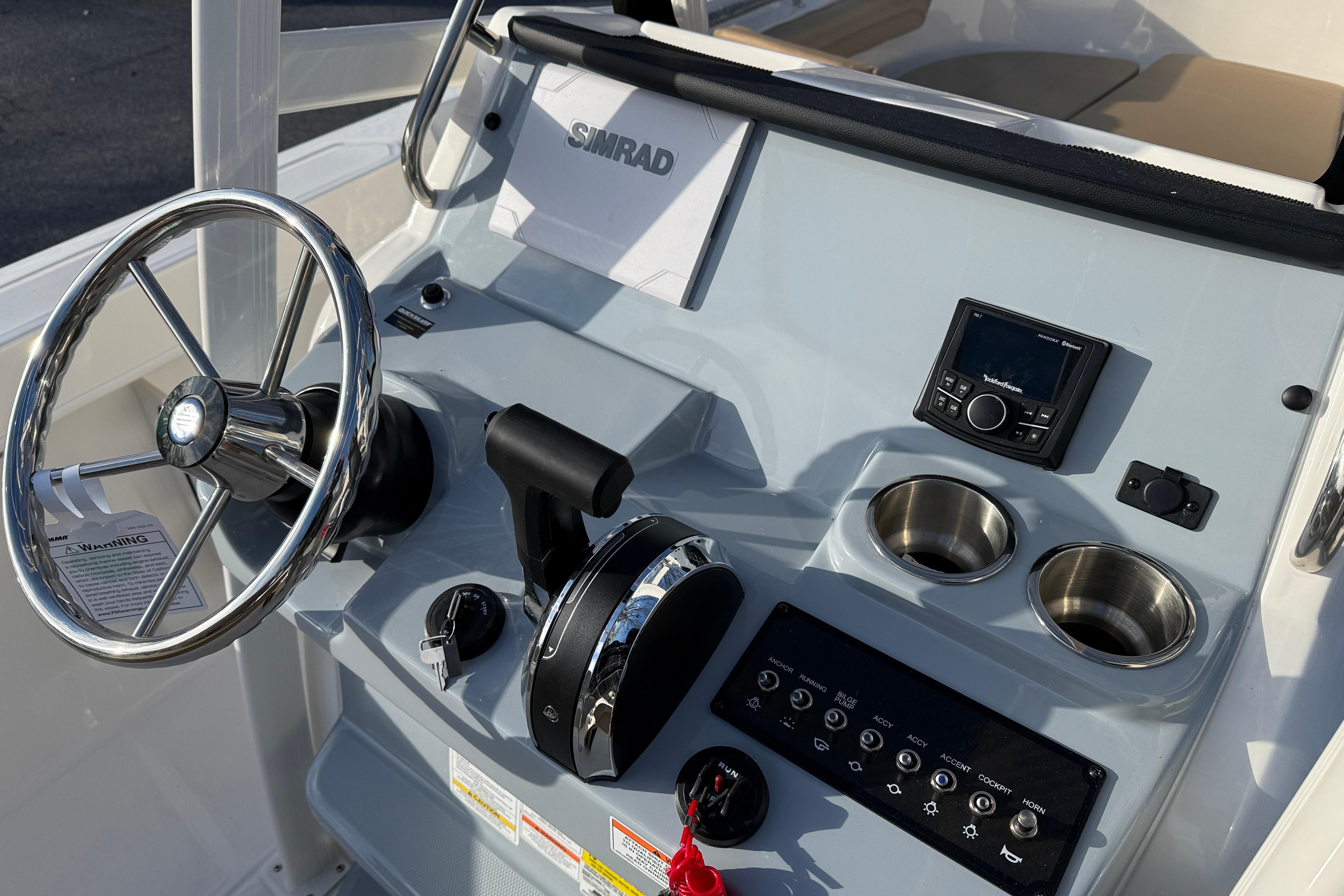 2026 Bayliner Trophy T22CC helm with steering wheel, controls, and cup holders.