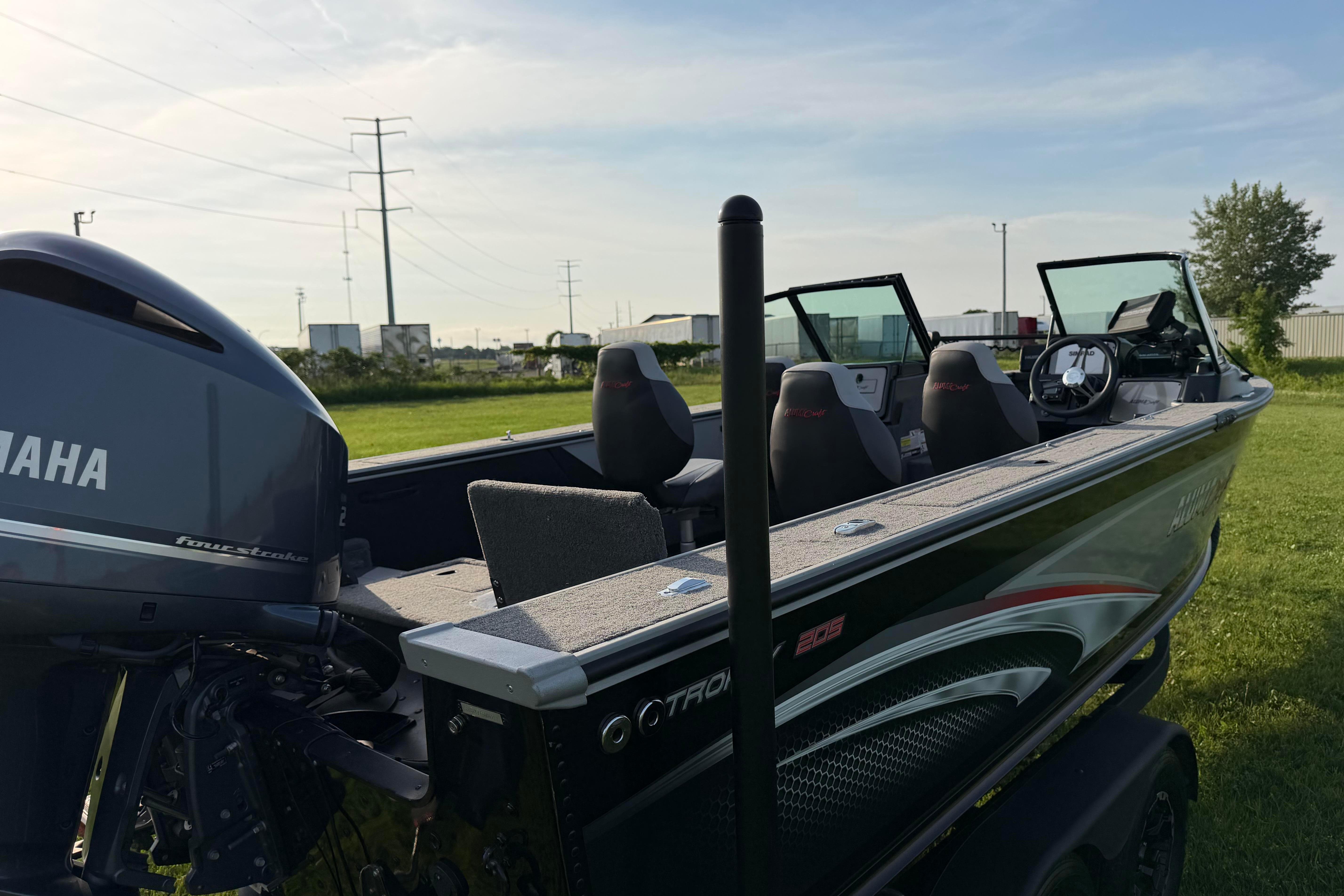 2019 Alumacraft Trophy 205 boat with Yamaha engine on grassy field.