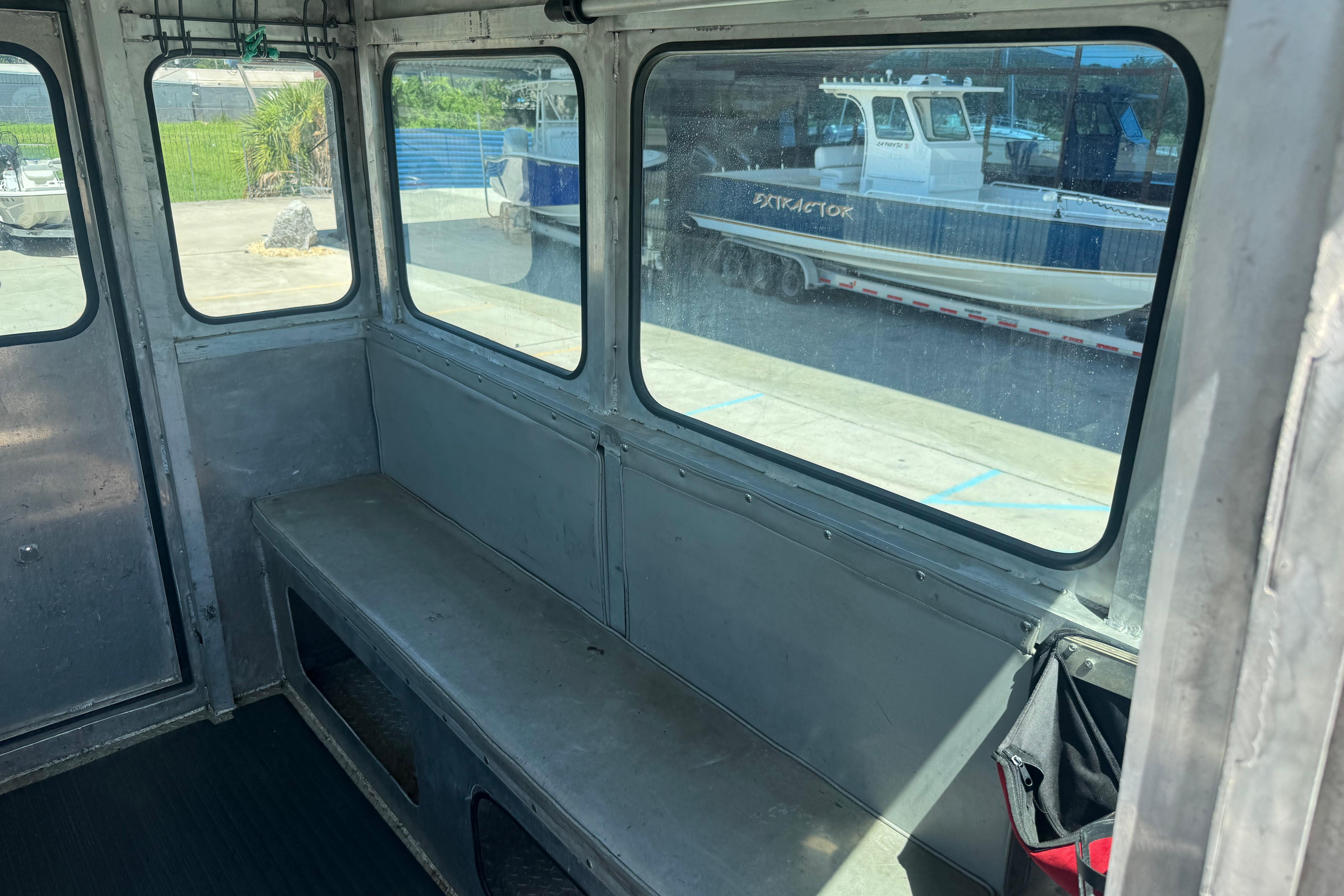 Interior of 2010 Custom Aluminum Work Boat 33 with bench seating and windows.