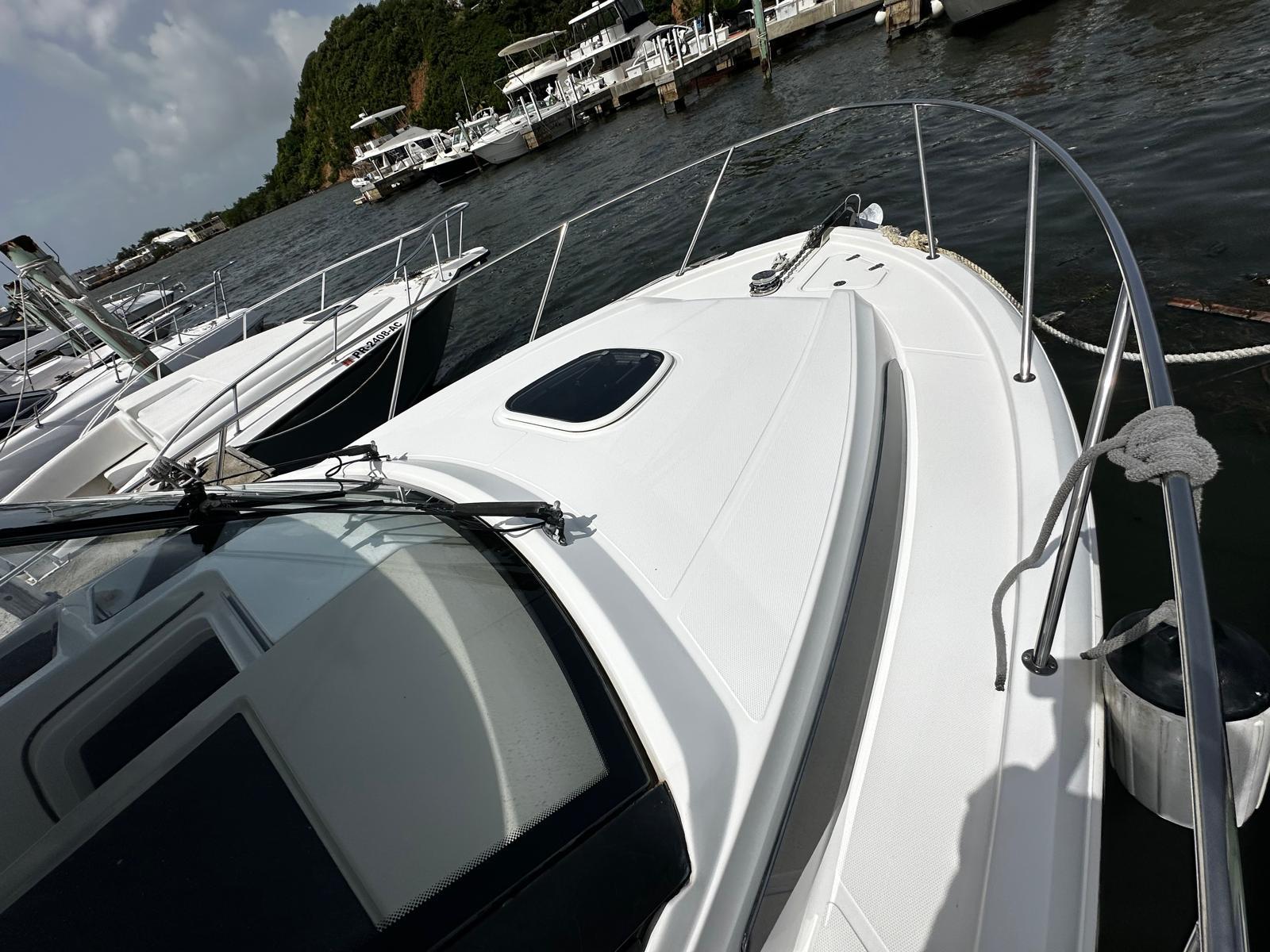 2020 Boston Whaler 325 Conquest docked at marina, surrounded by other boats.