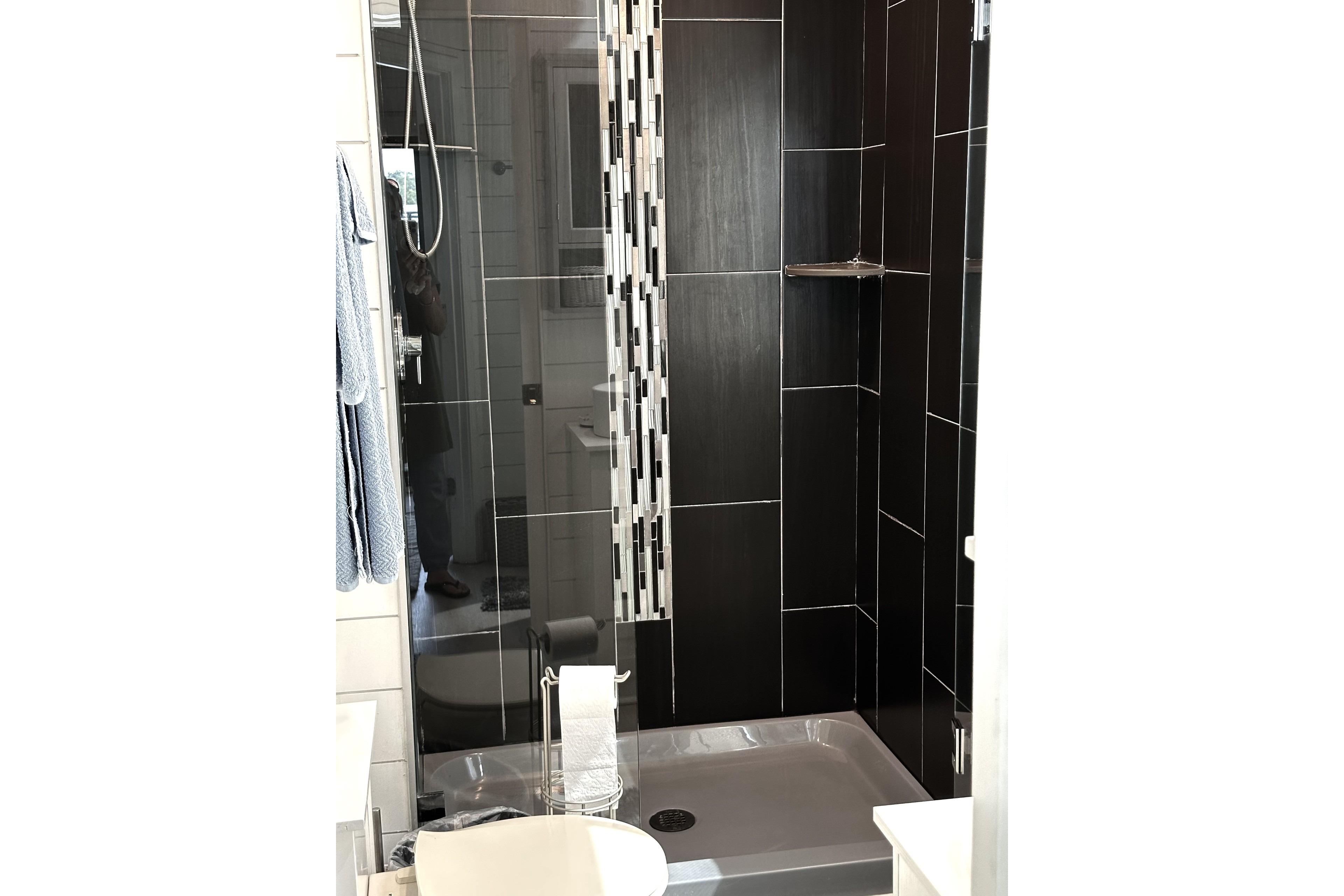 Modern black-tiled shower in 1992 Sumerset 66 houseboat bathroom.