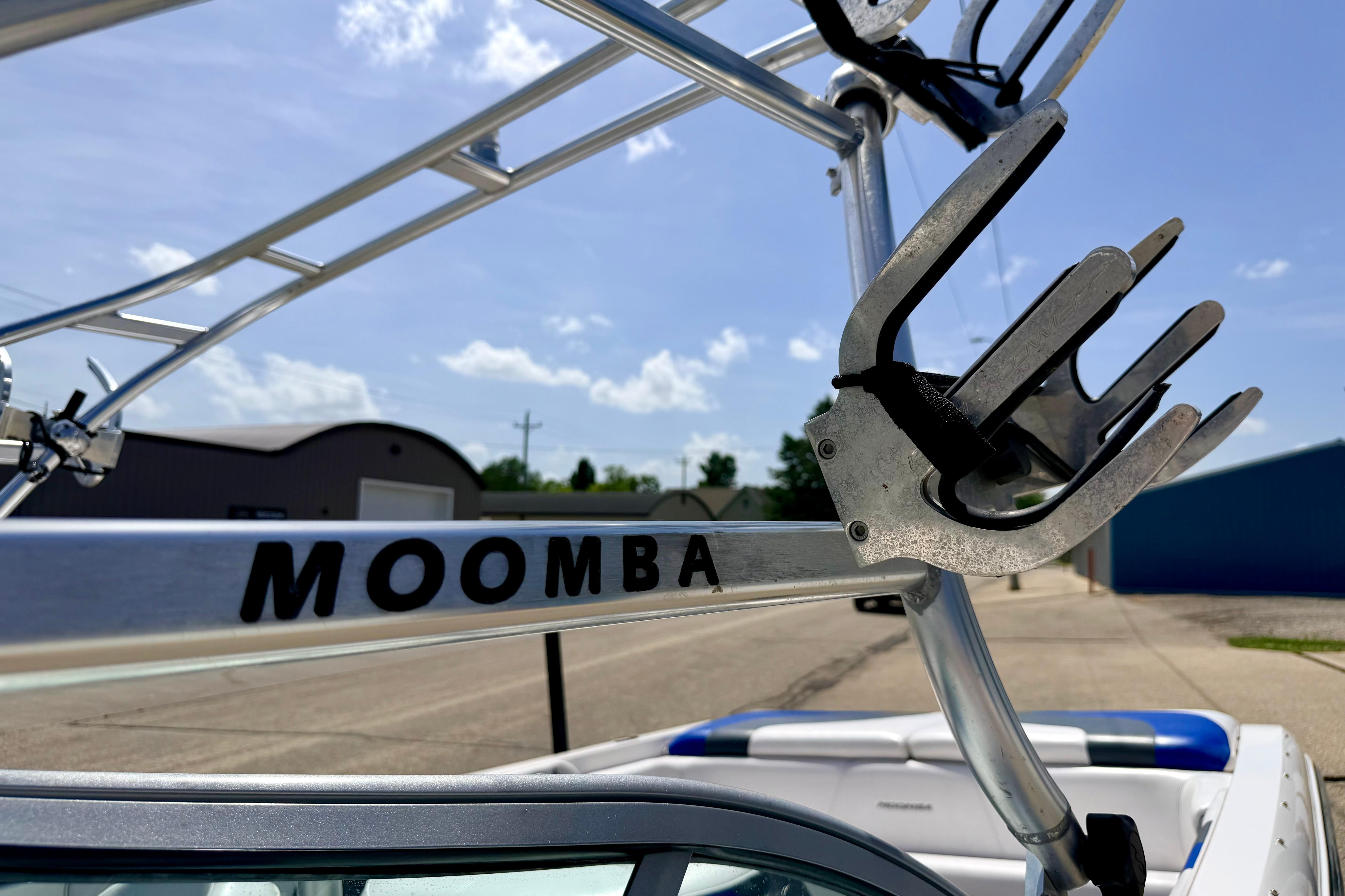 2008 Moomba Outback V boat tower with wakeboard rack under clear blue sky.