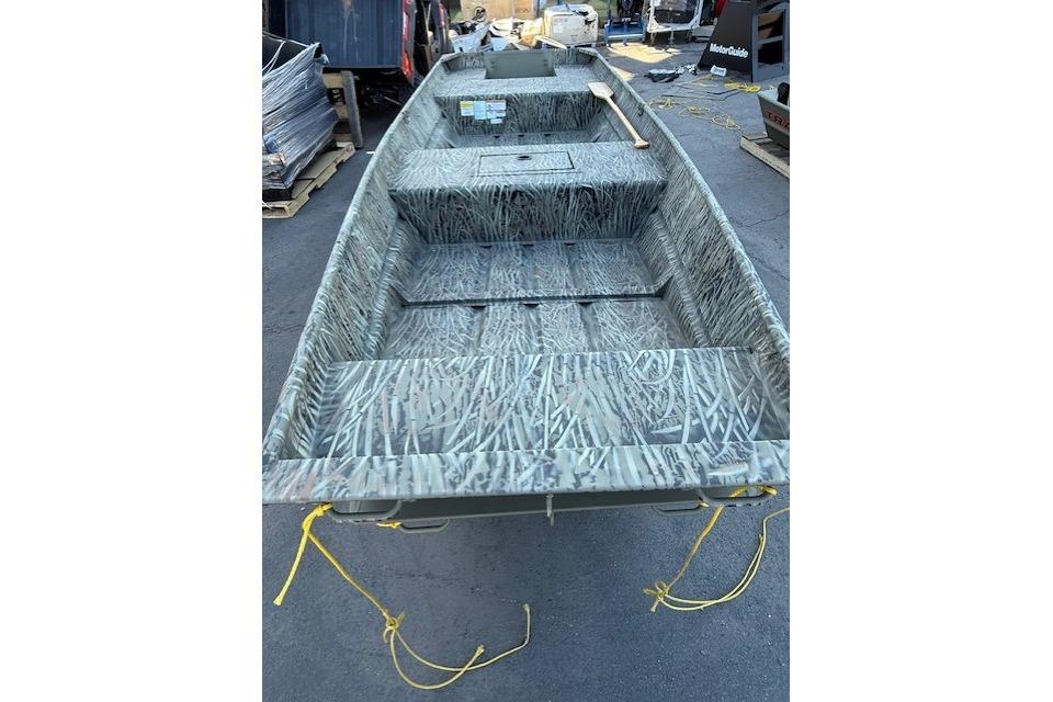 2026 Tracker Grizzly 15 Jon boat with camouflage interior, parked outdoors.