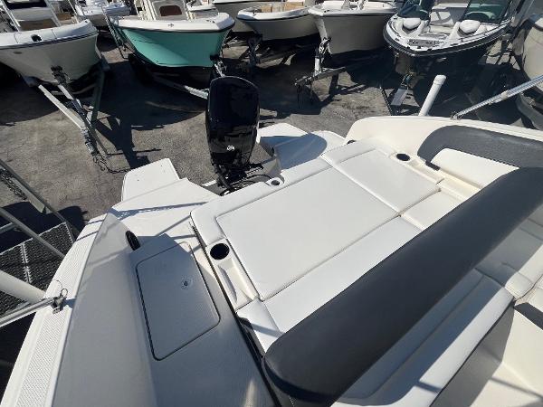 2021 Bayliner DX 2200 boat with spacious seating and outboard motor in a marina.