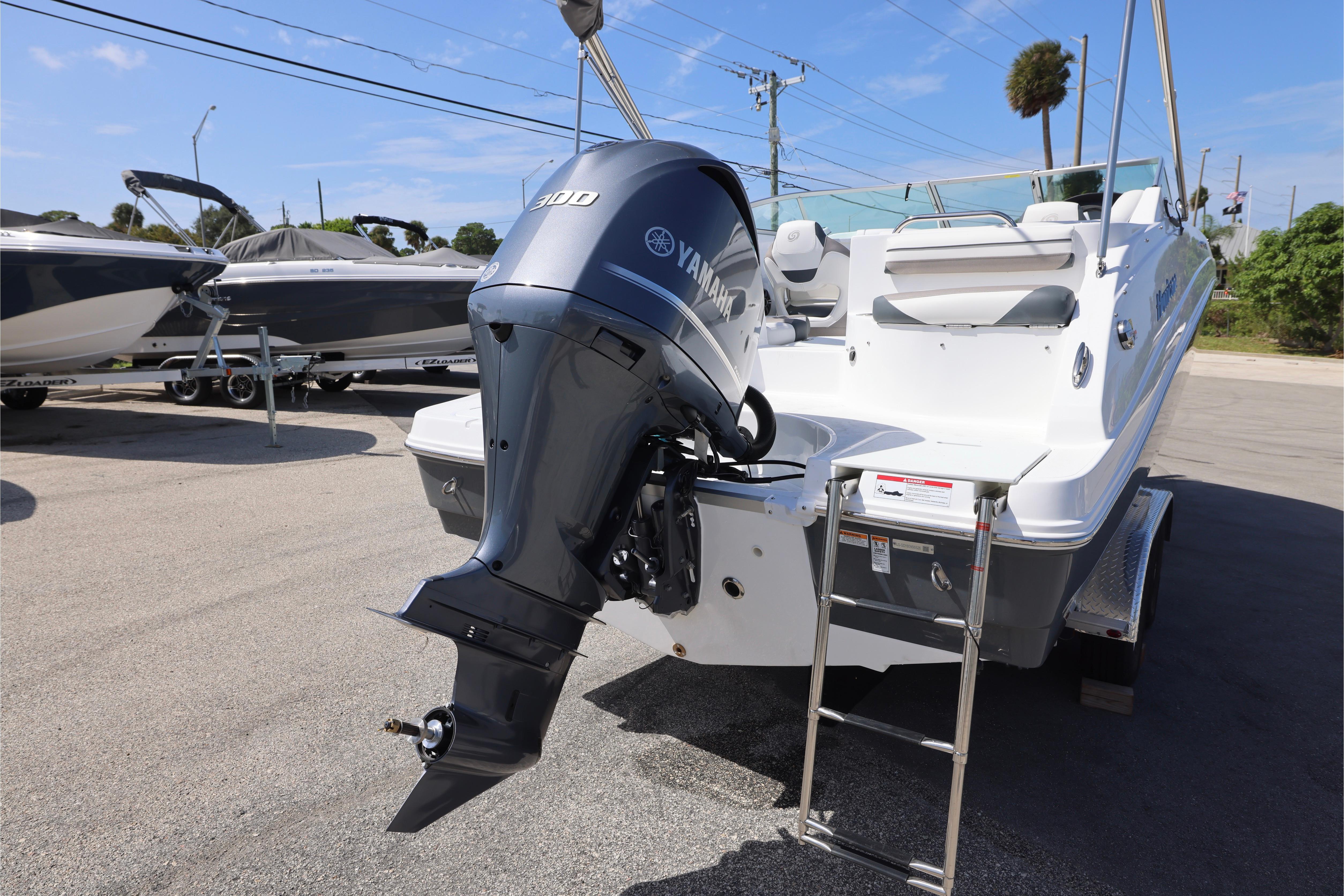 2026 Hurricane SunDeck 2486 OB boat with Yamaha outboard motor, parked on a trailer.