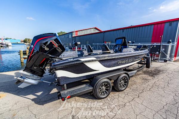 2024 Recon 985 SC boat with powerful outboard motor on trailer near waterfront.