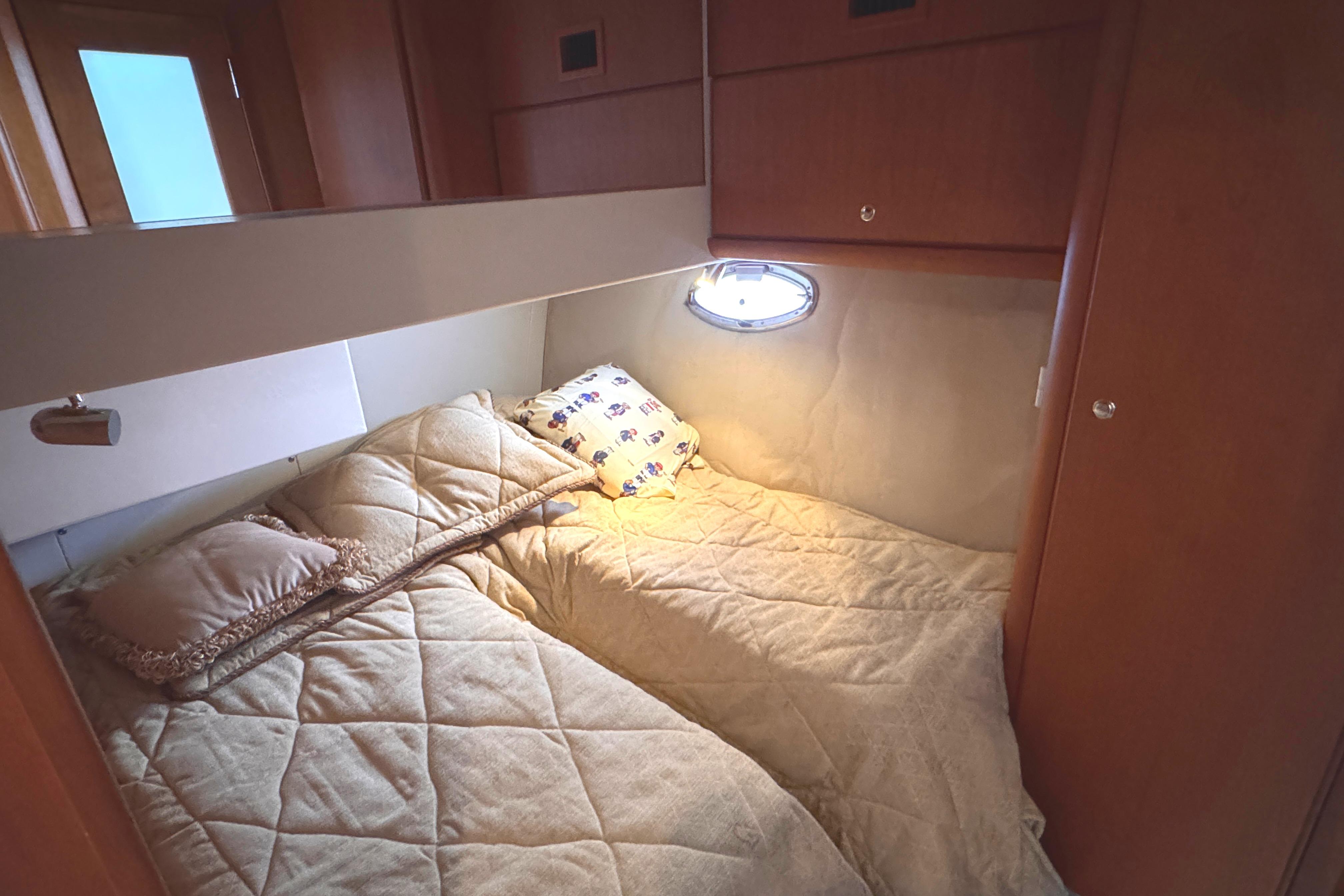 Cozy cabin interior of 2004 Silverton 38 Convertible yacht with comfortable bedding.