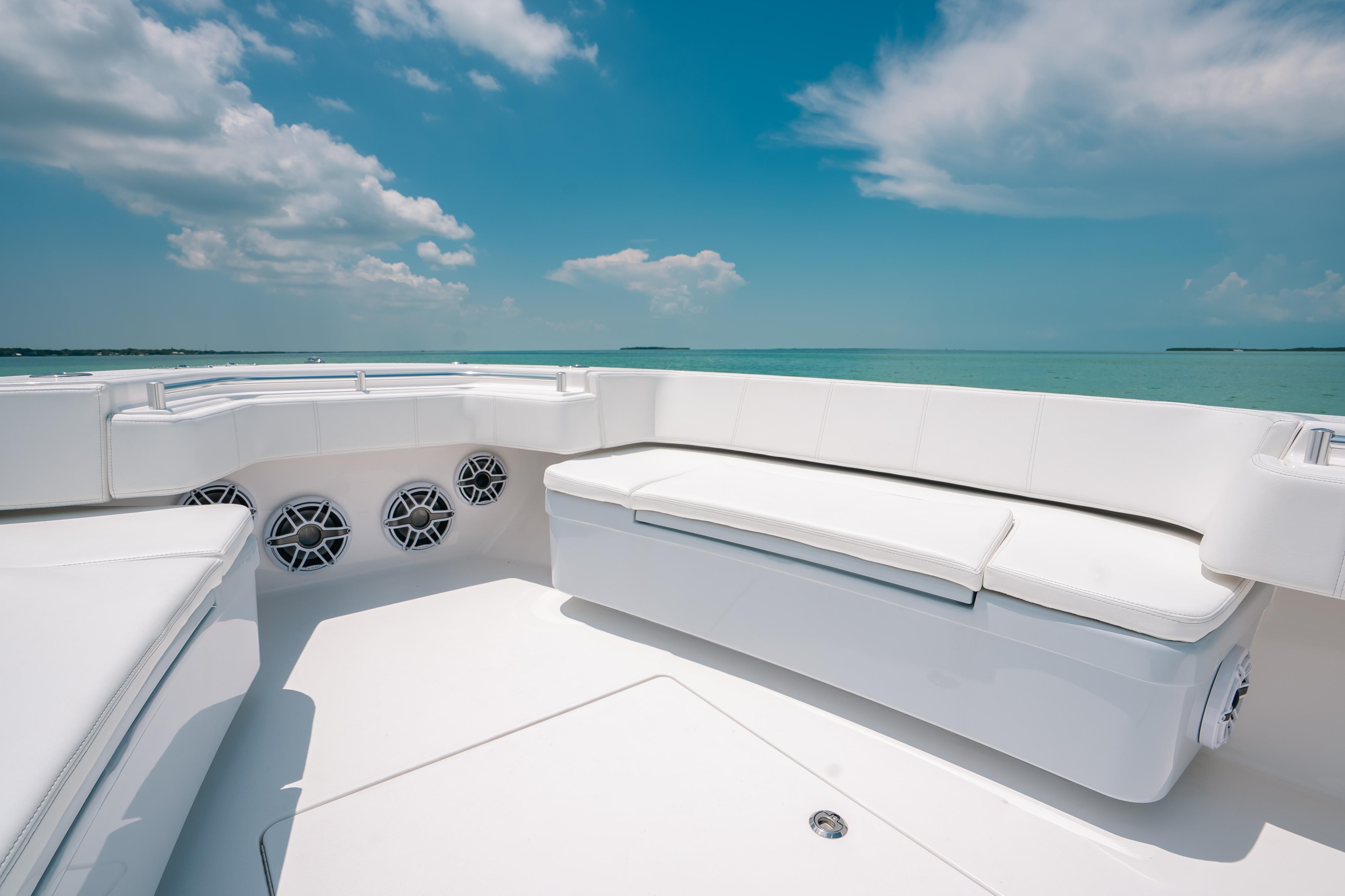 Luxurious seating on 2025 Contender 44 ST boat under clear blue sky.