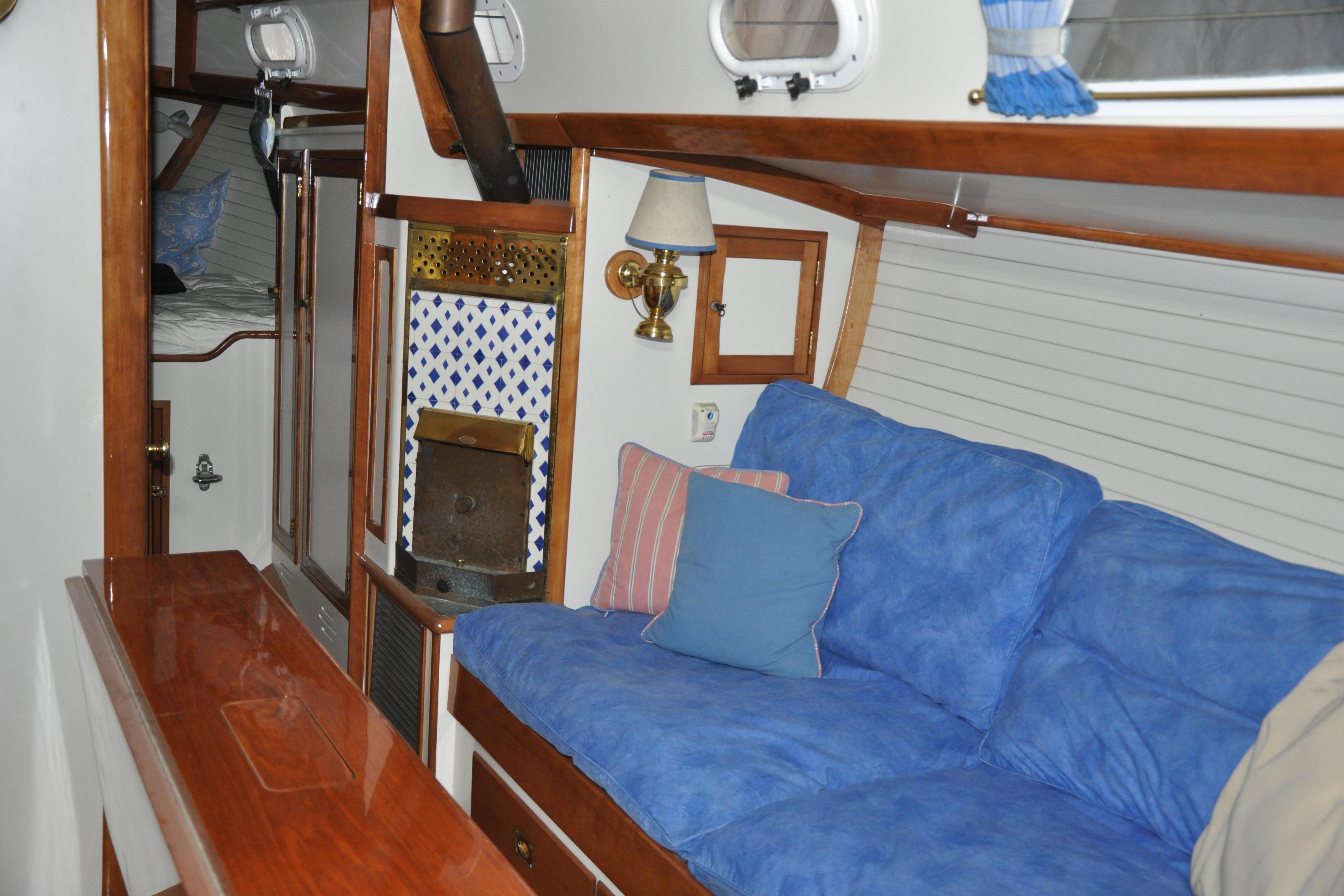 Interior of a 1970 Hinckley Bermuda 40 sailboat with blue cushions and wooden accents.