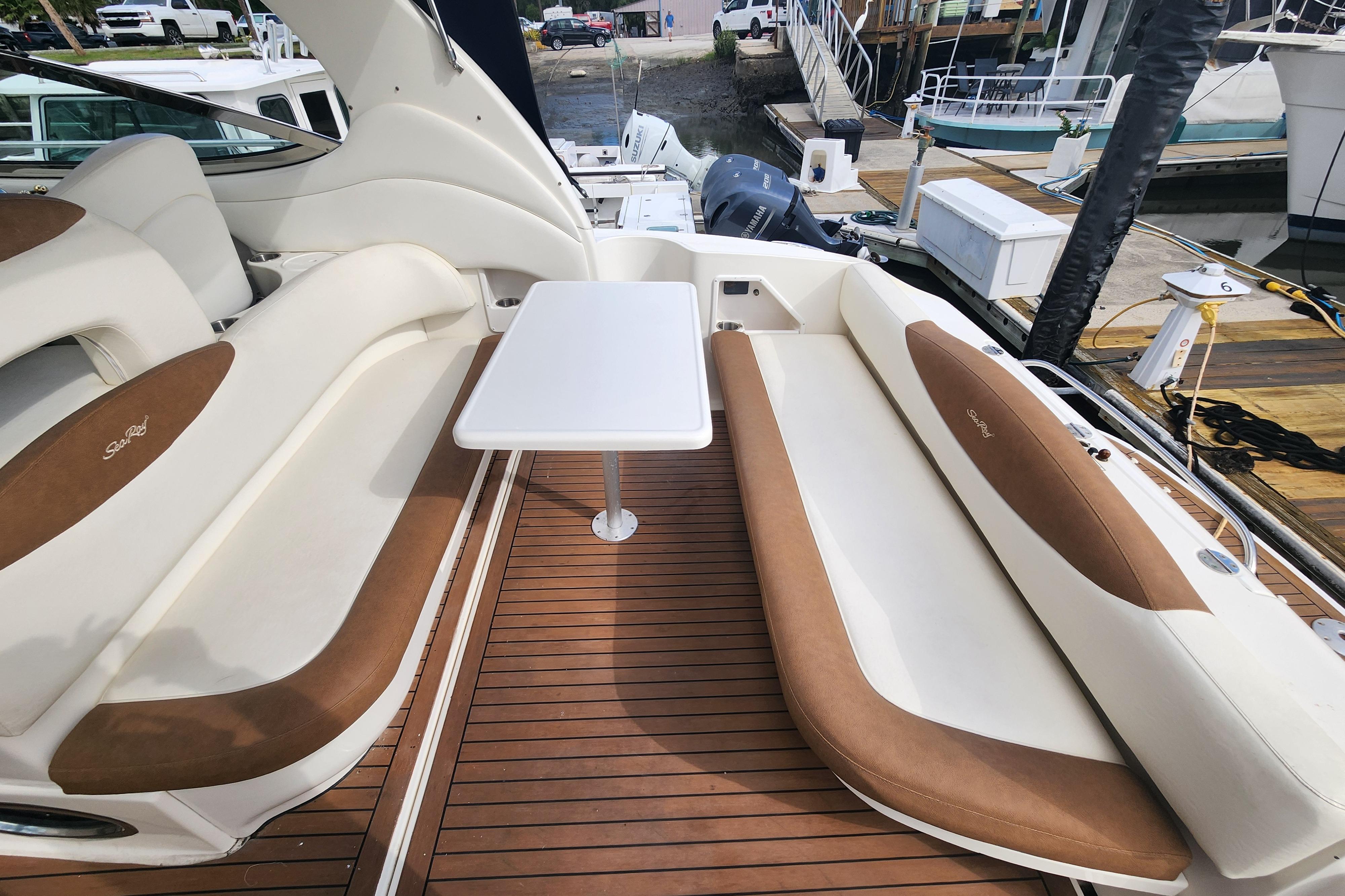 2003 Sea Ray 360 Sundancer cockpit with white table and cushioned seating.