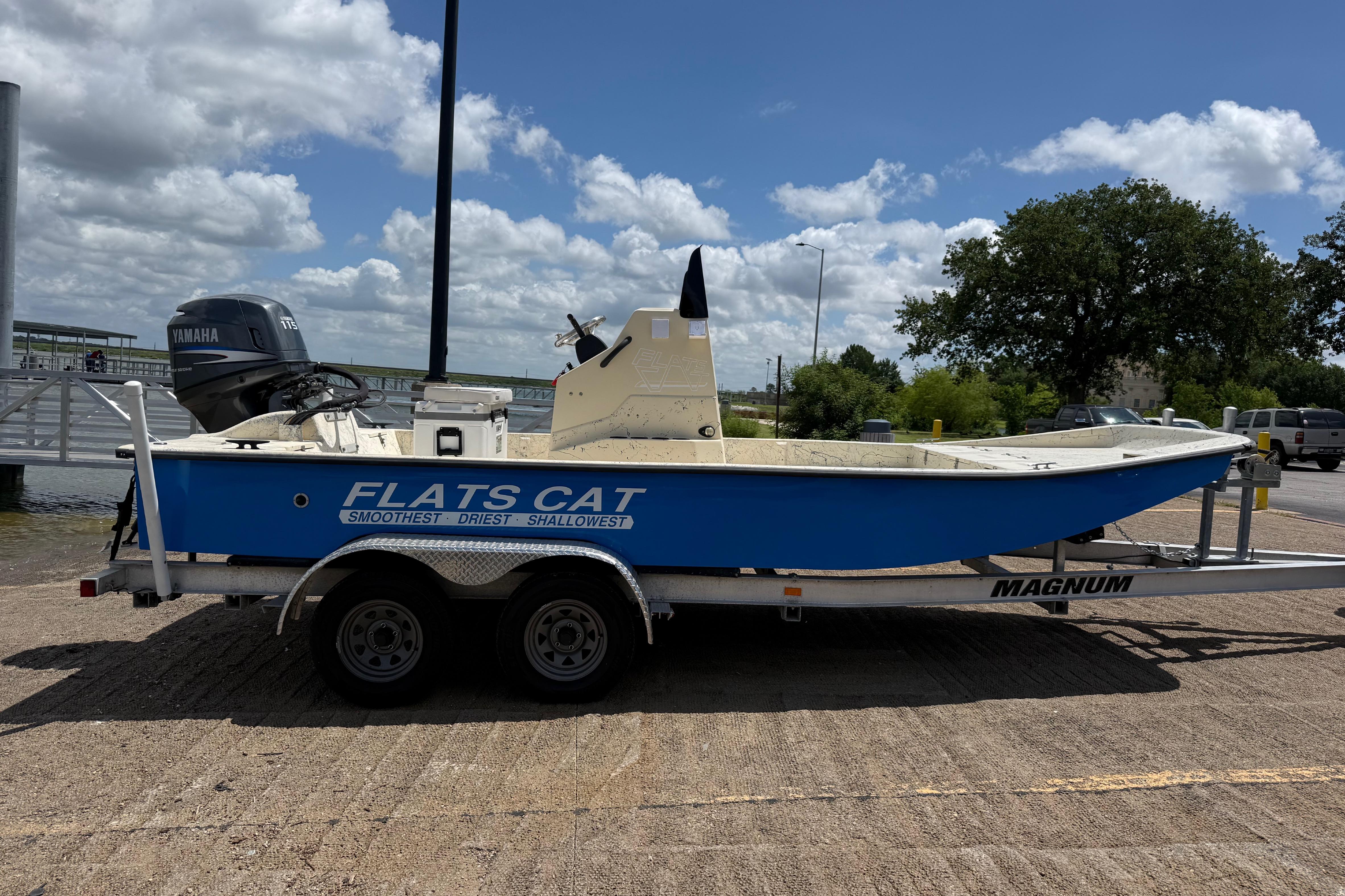 2007 Flats Cat 19 boat on trailer, featuring Yamaha outboard motor, under a clear blue sky.