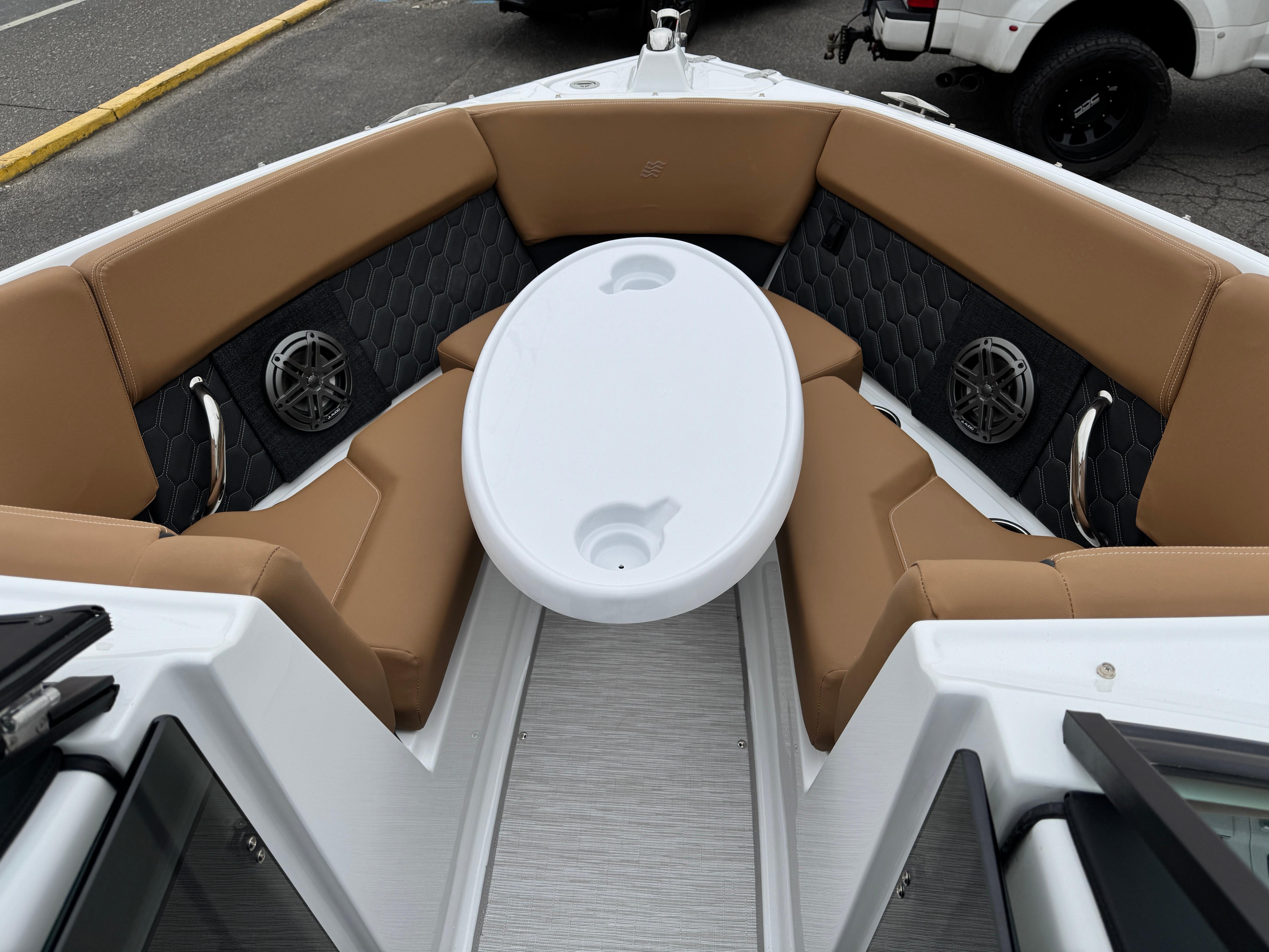 2025 Four Winns H2 OB boat interior with tan seating and white table.