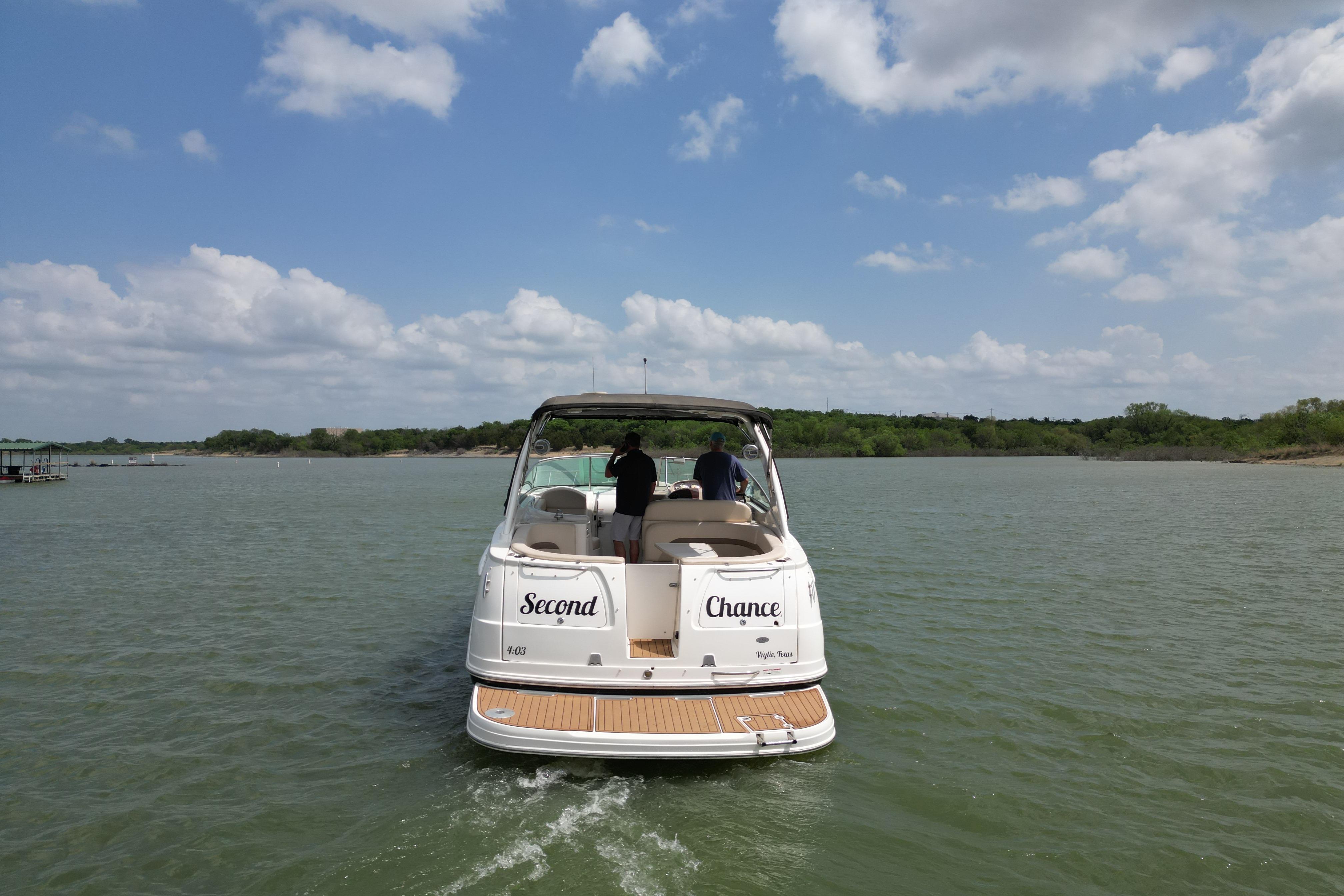 2006 Chaparral 330 Signature boat cruising on a lake under a partly cloudy sky.
