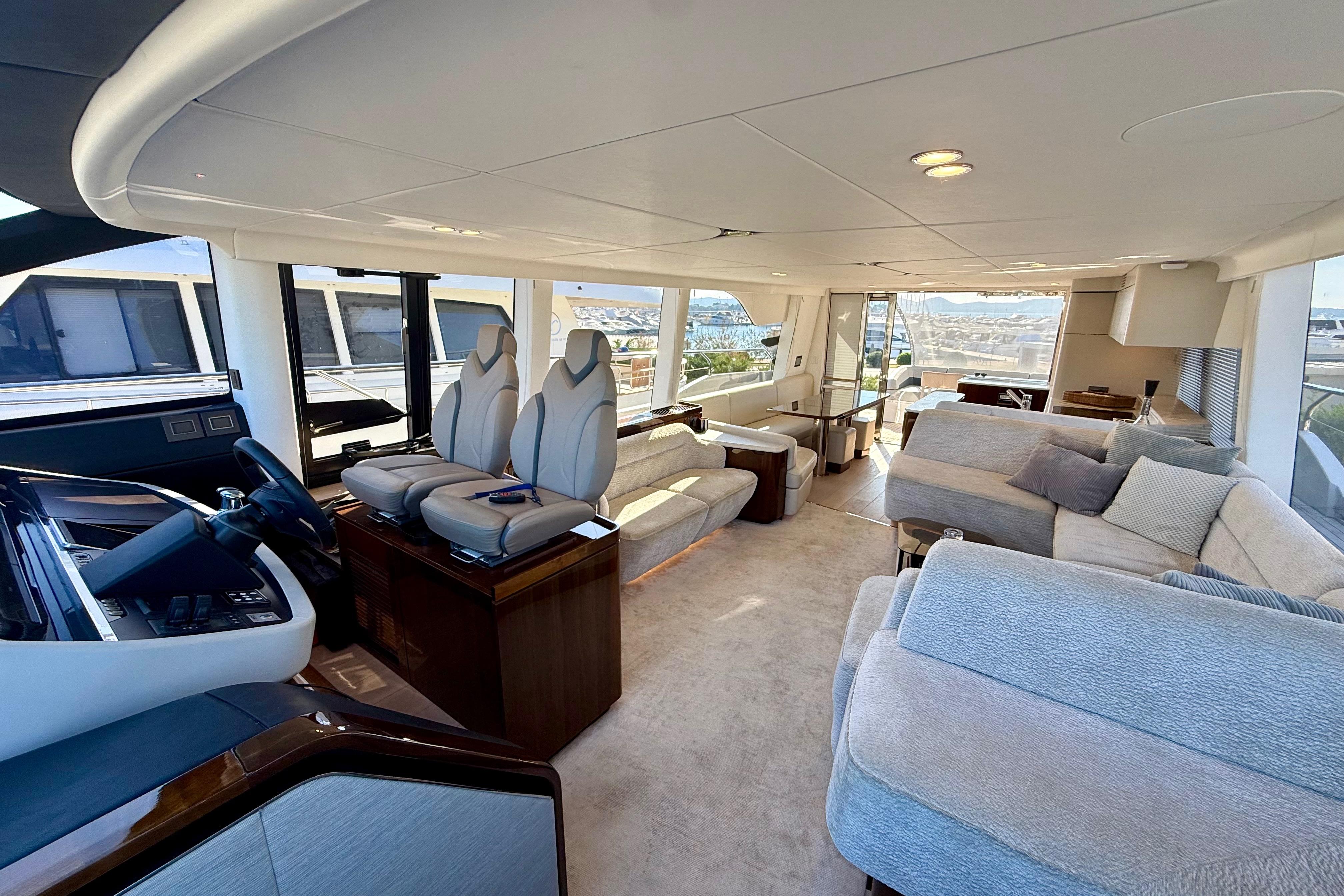 Luxurious interior of 2022 Fairline Squadron 68 yacht with modern seating and panoramic windows.