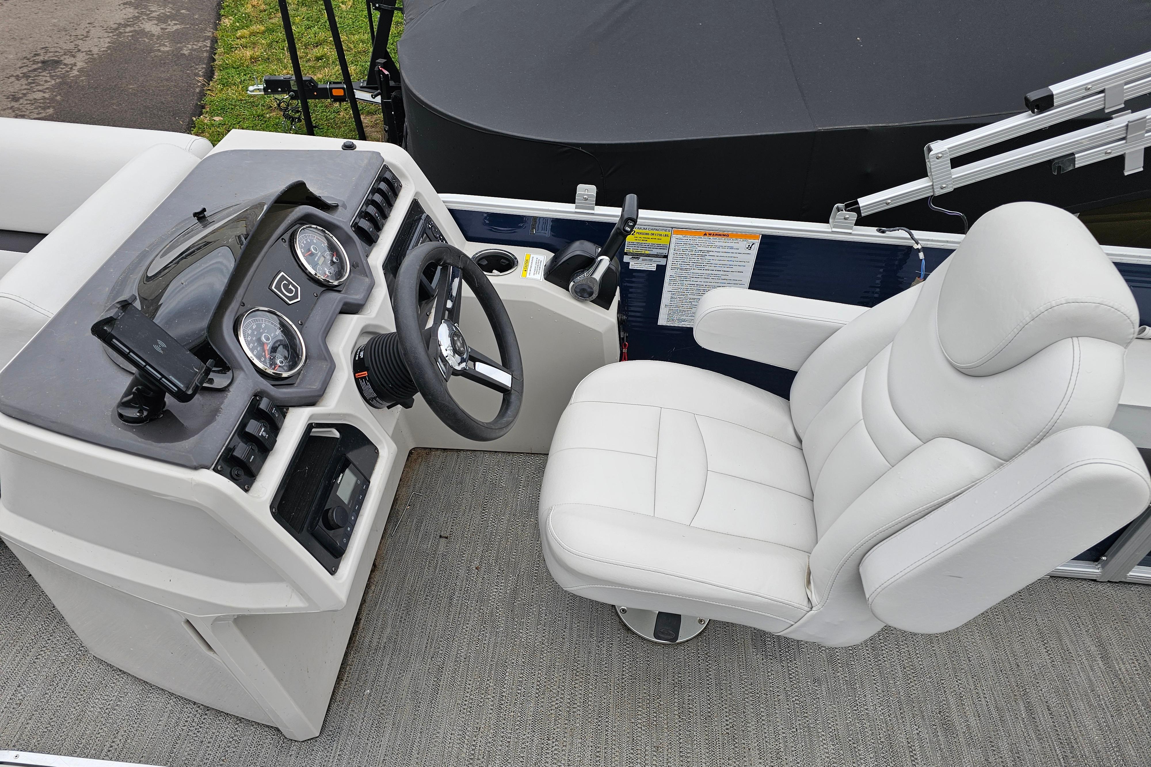 2022 Sweetwater 2286 SFL boat interior with steering console and white captain's chair.