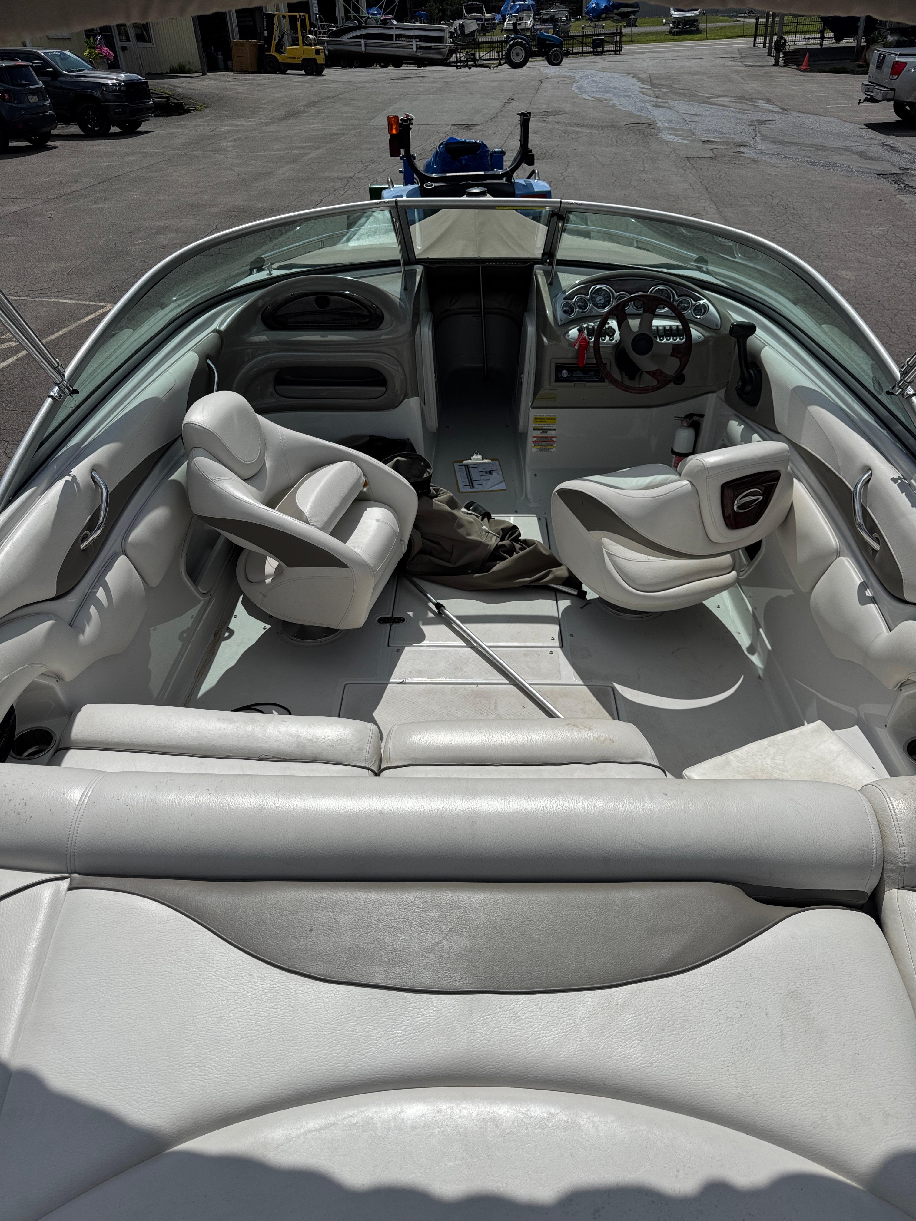 2008 Crownline 220 LS boat interior with seating and steering wheel, parked on pavement.
