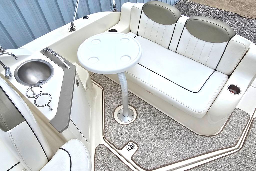 2006 Sea Ray 240 Sundancer interior with seating, table, and sink.
