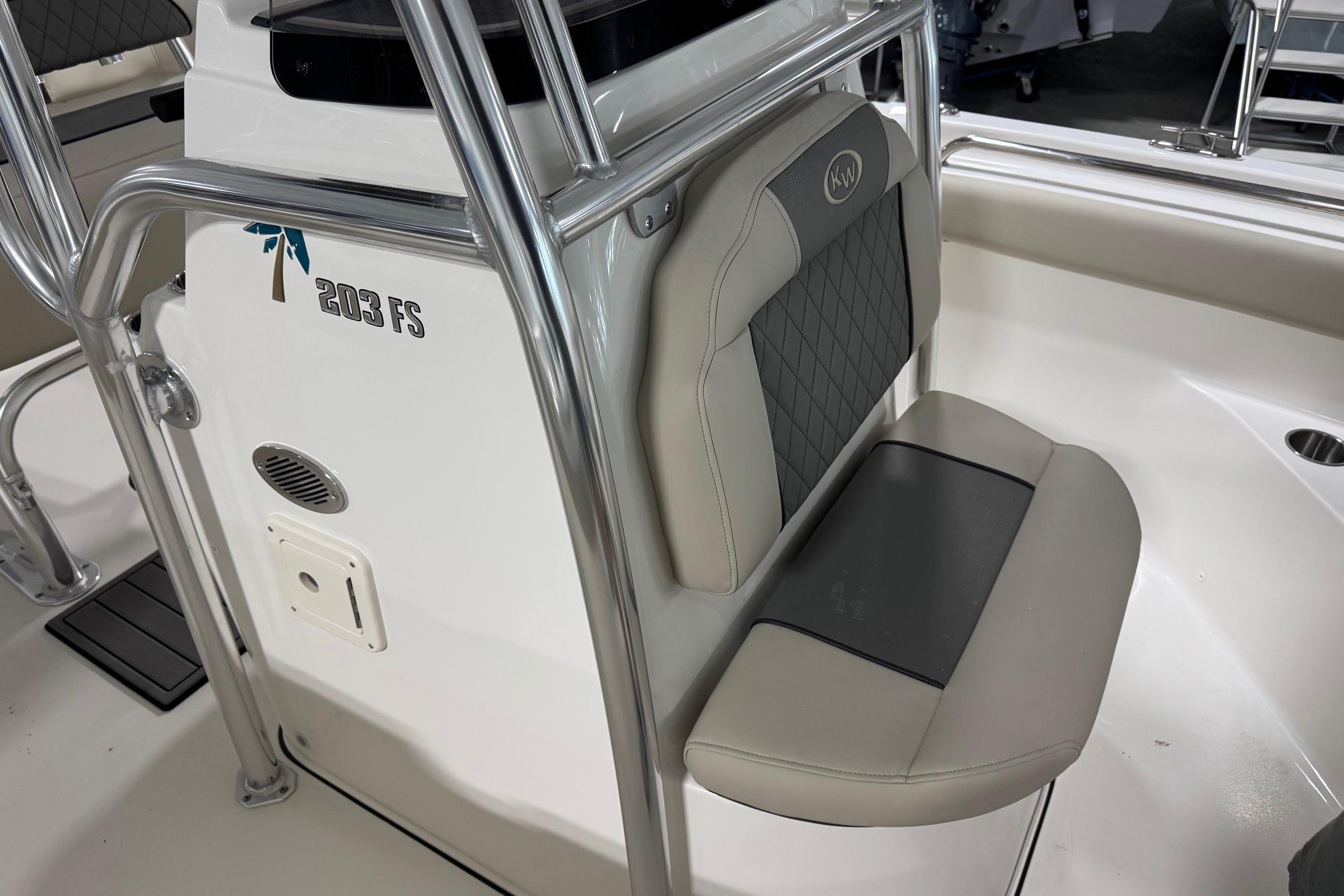 2026 Key West 203 FS boat interior with cushioned seating and stainless steel railing.