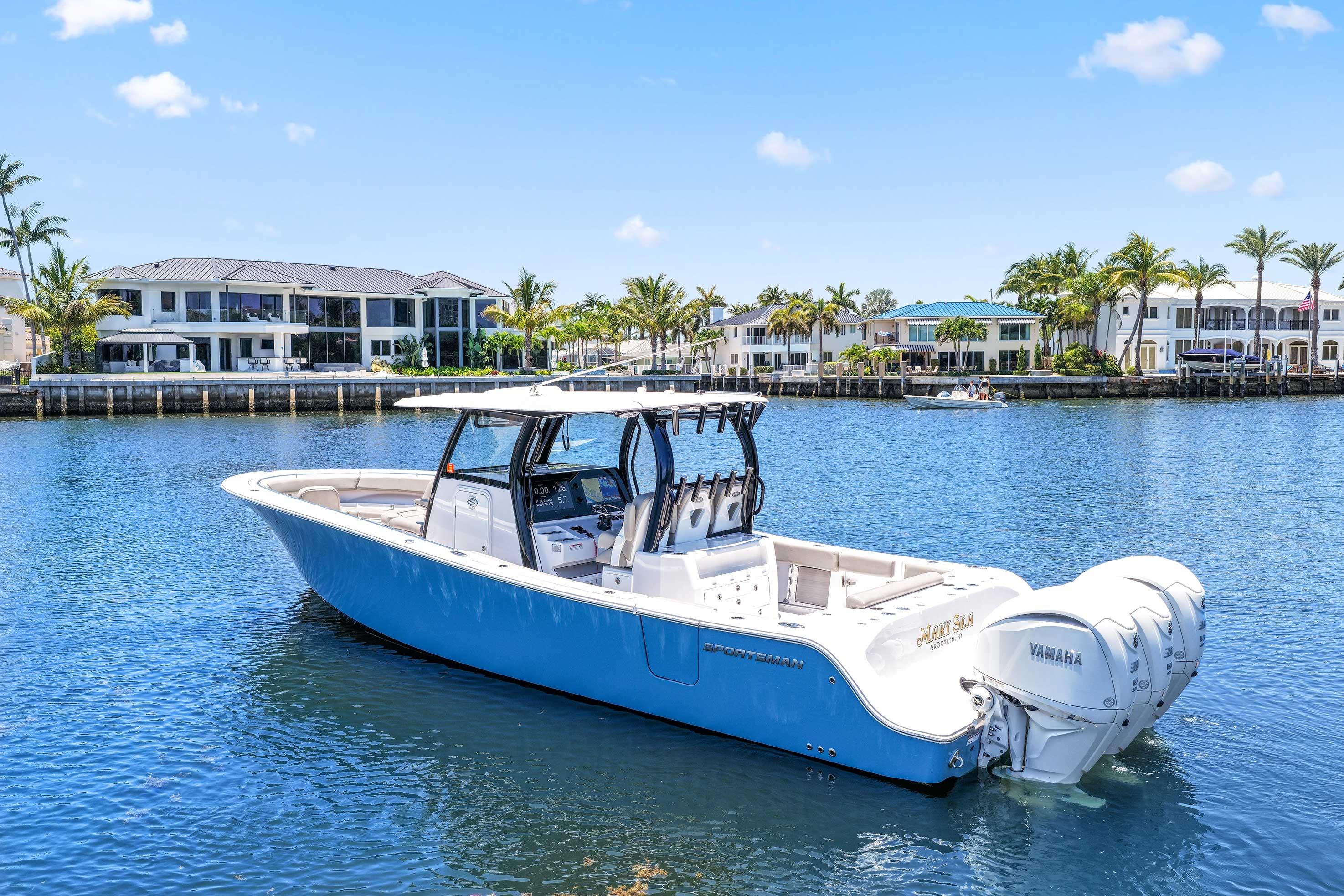 2024 Sportsman Open 352 Center Console boat on water, with luxury waterfront homes in background.