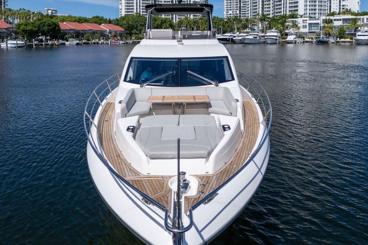 2023 Sunseeker Manhattan 68 yacht on calm water, showcasing luxurious deck seating.