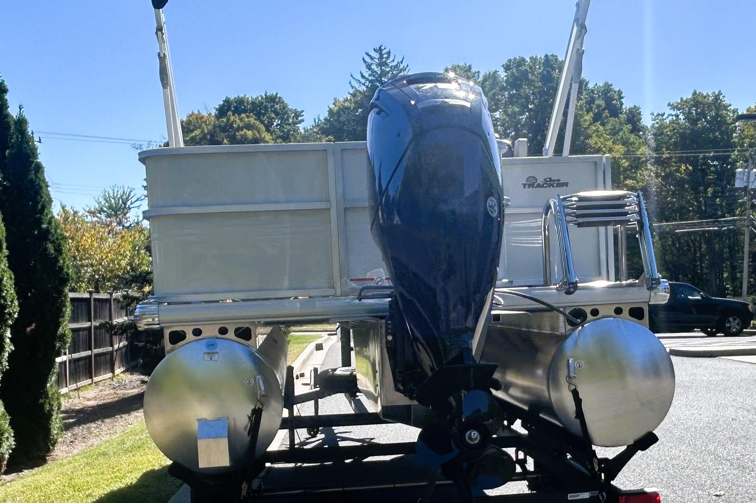 2026 Sun Tracker Party Barge 18 DLX pontoon boat with outboard motor, parked outdoors.