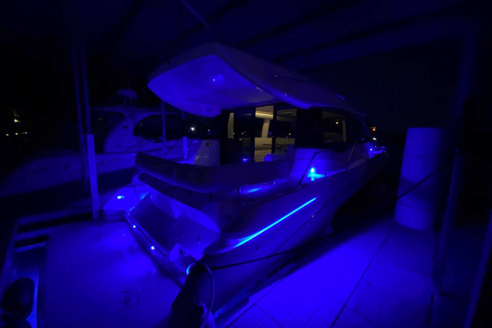 2018 Regal 42 Grande Coupe yacht illuminated with blue lights at night.