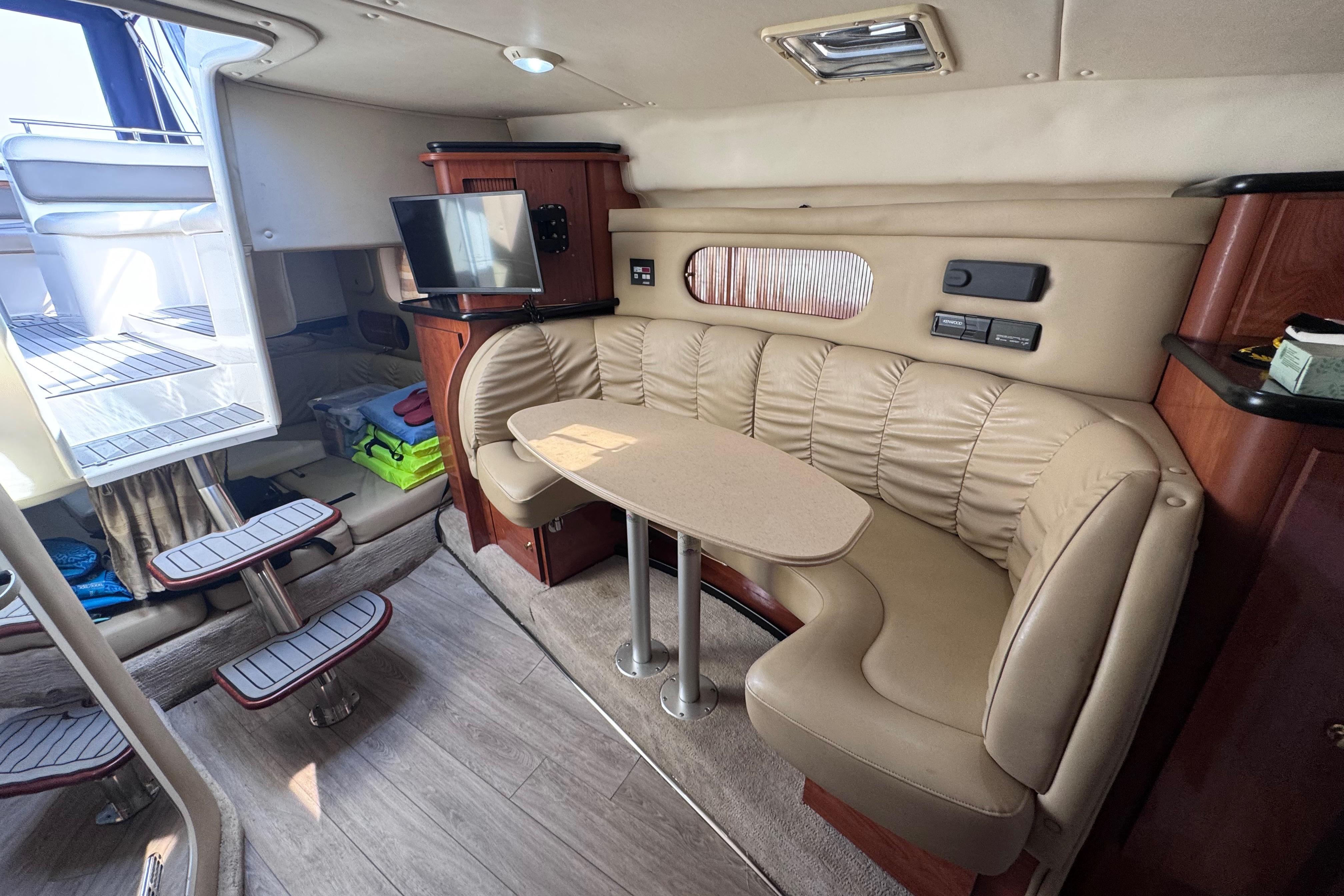 Interior of 2003 Rinker Fiesta Vee 312 yacht with beige seating and compact dining area.