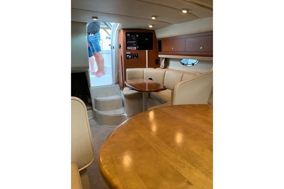 Interior of 2003 Chaparral Signature 280 boat with cozy seating and wooden table.