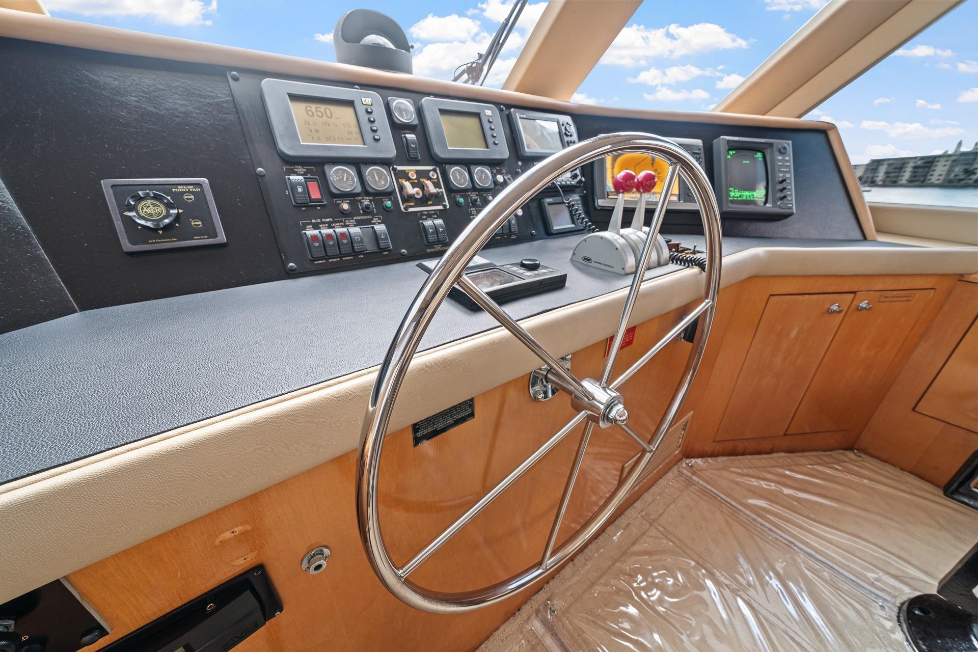 Helm of 2002 Hatteras 60 Convertible yacht with steering wheel and navigation instruments.