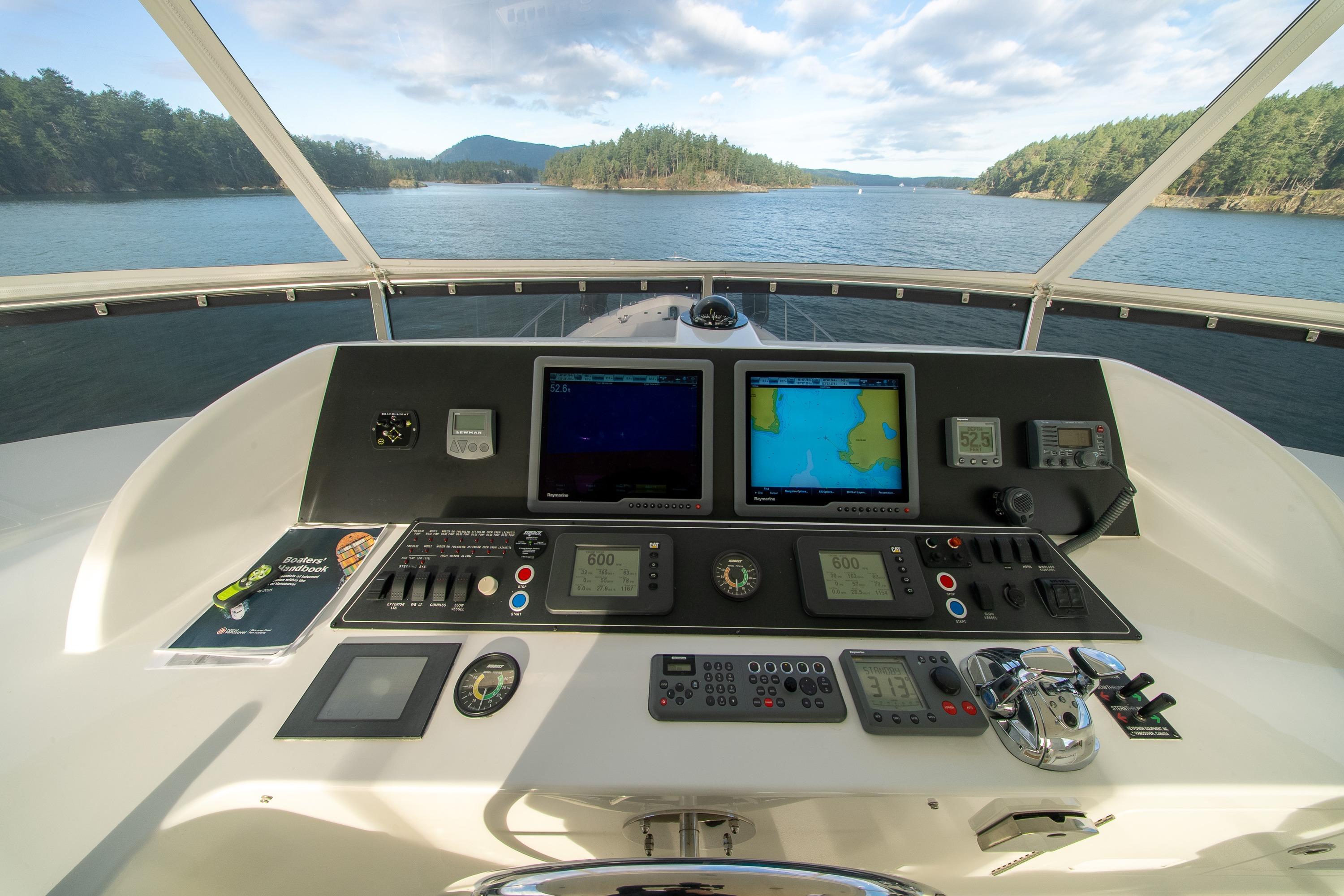 Pilothouse of 2007 Ocean Alexander 74, featuring navigation equipment and scenic water view.
