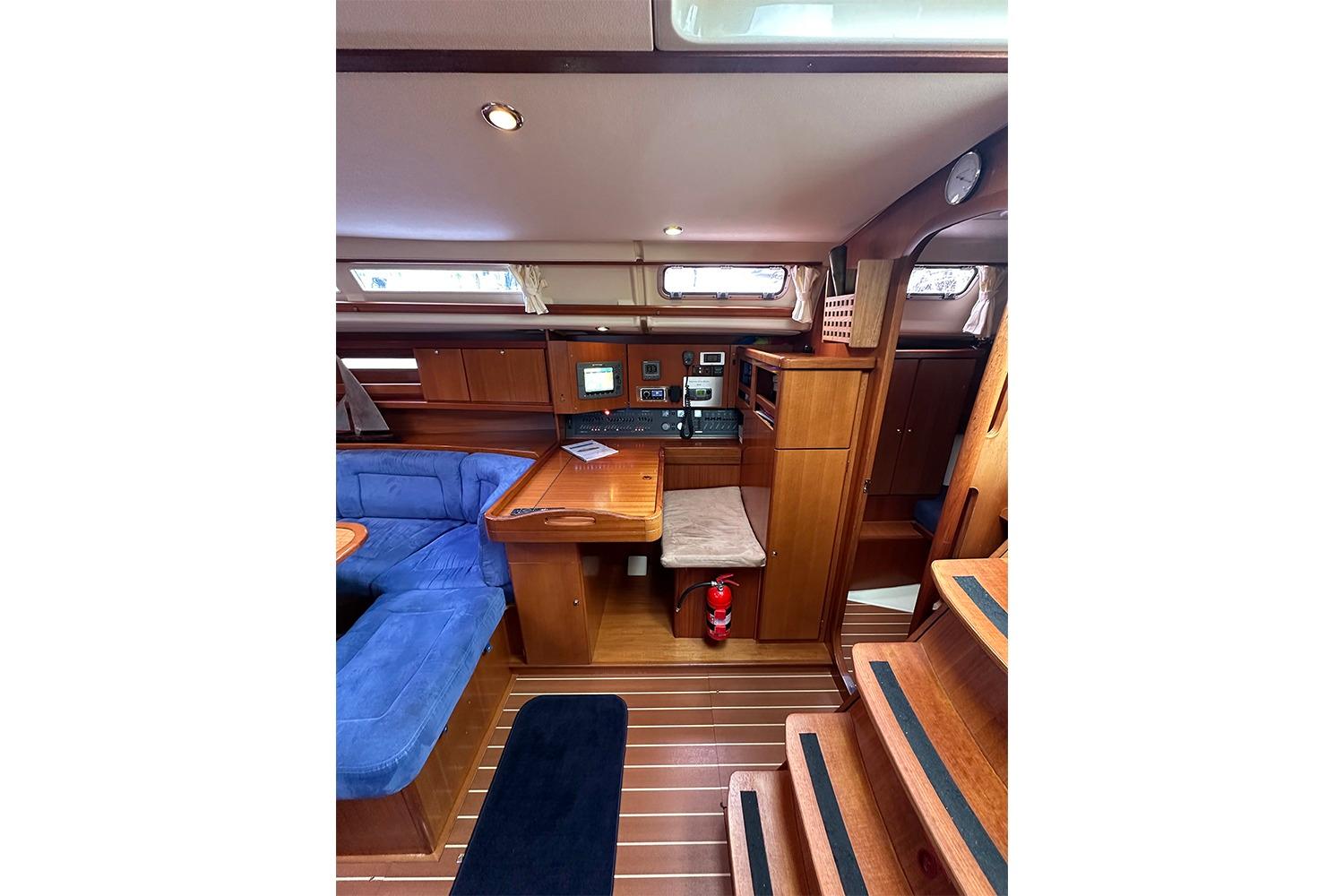 Interior of 2007 Dufour 455 GL yacht with wooden finish and blue seating.