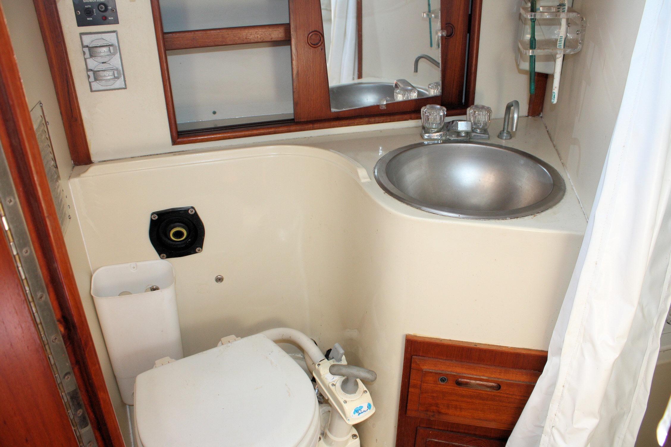 Compact bathroom in a 1987 Ericson 38-200 yacht with sink and toilet.