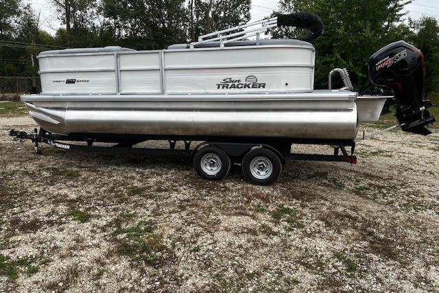 2026 Sun Tracker Party Barge 20 DLX pontoon boat on trailer, parked outdoors.