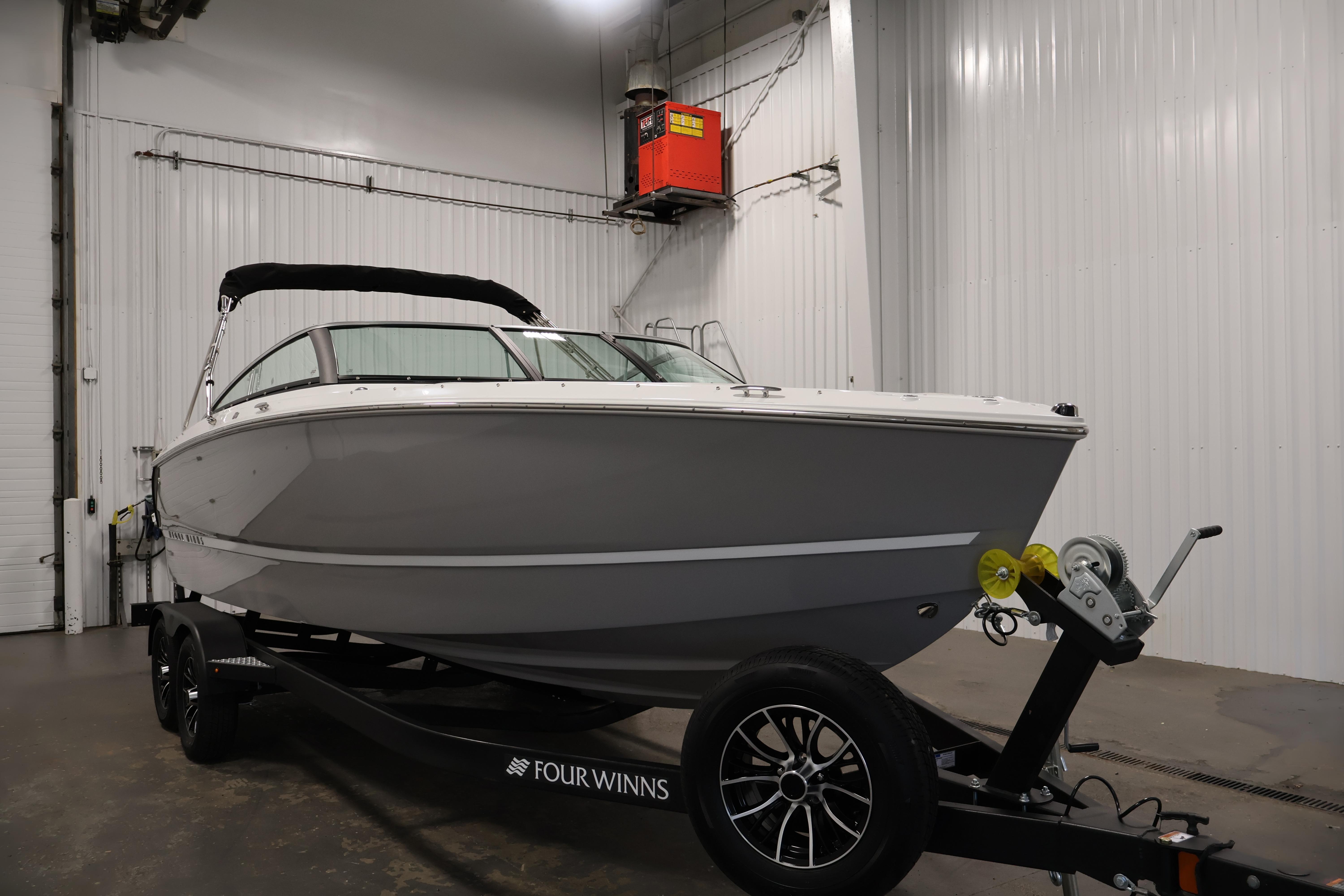 2026 Four Winns H4 Freedom boat on trailer in indoor storage facility.