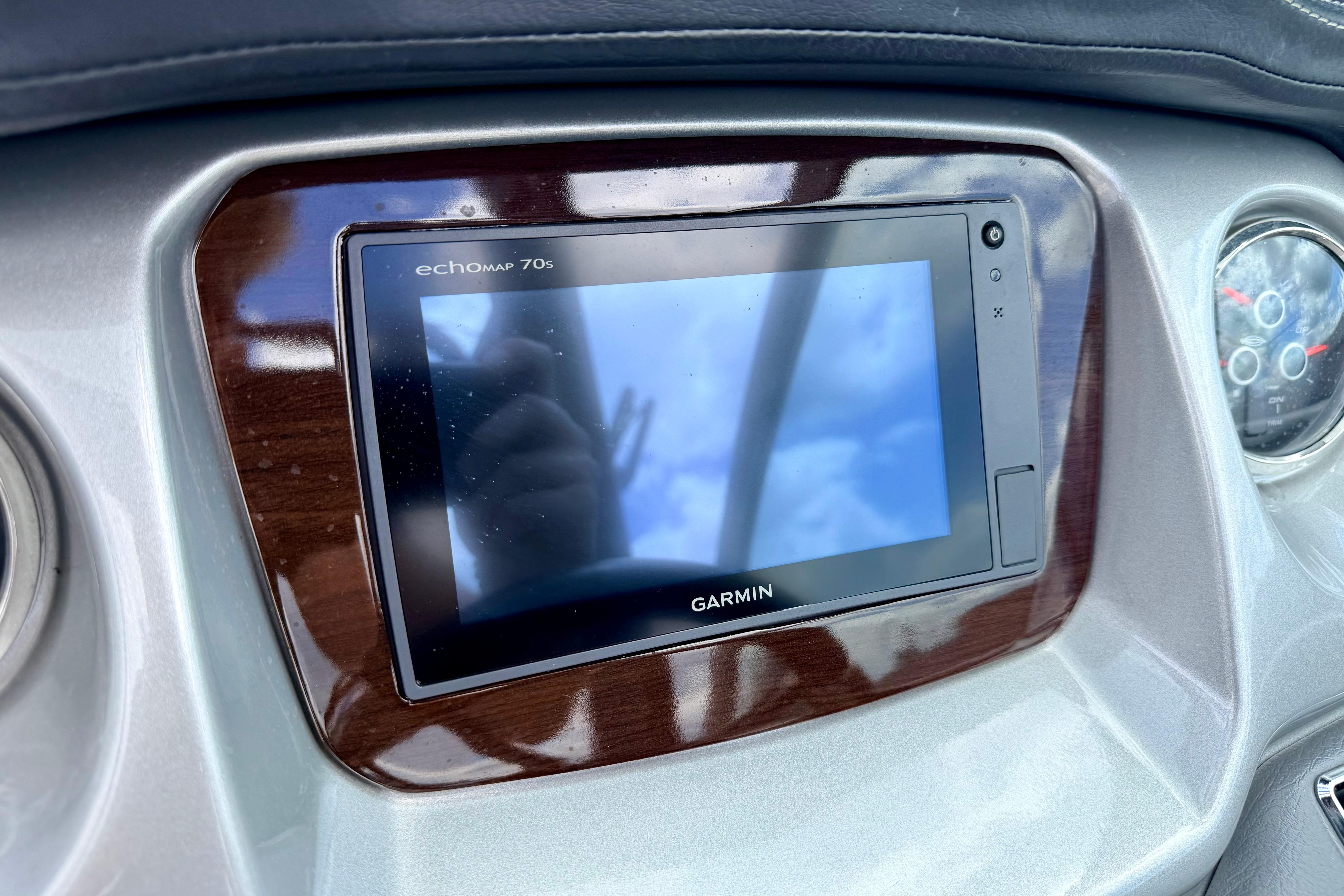 Garmin EchoMap 70s on 2015 Chaparral Sunesta 264 dashboard, reflecting sky.