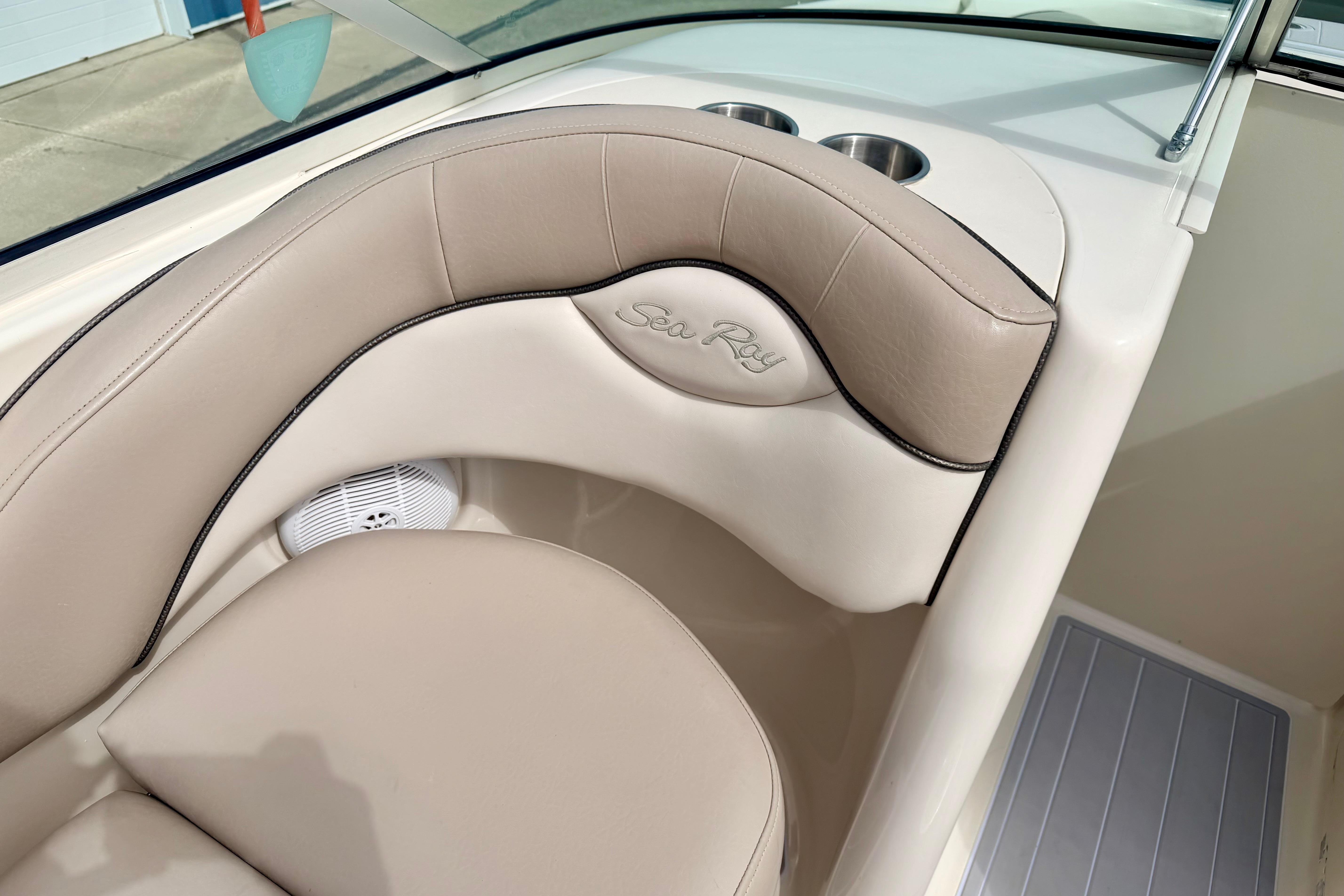 2003 Sea Ray 200 Sundeck interior with beige seating and cup holders.