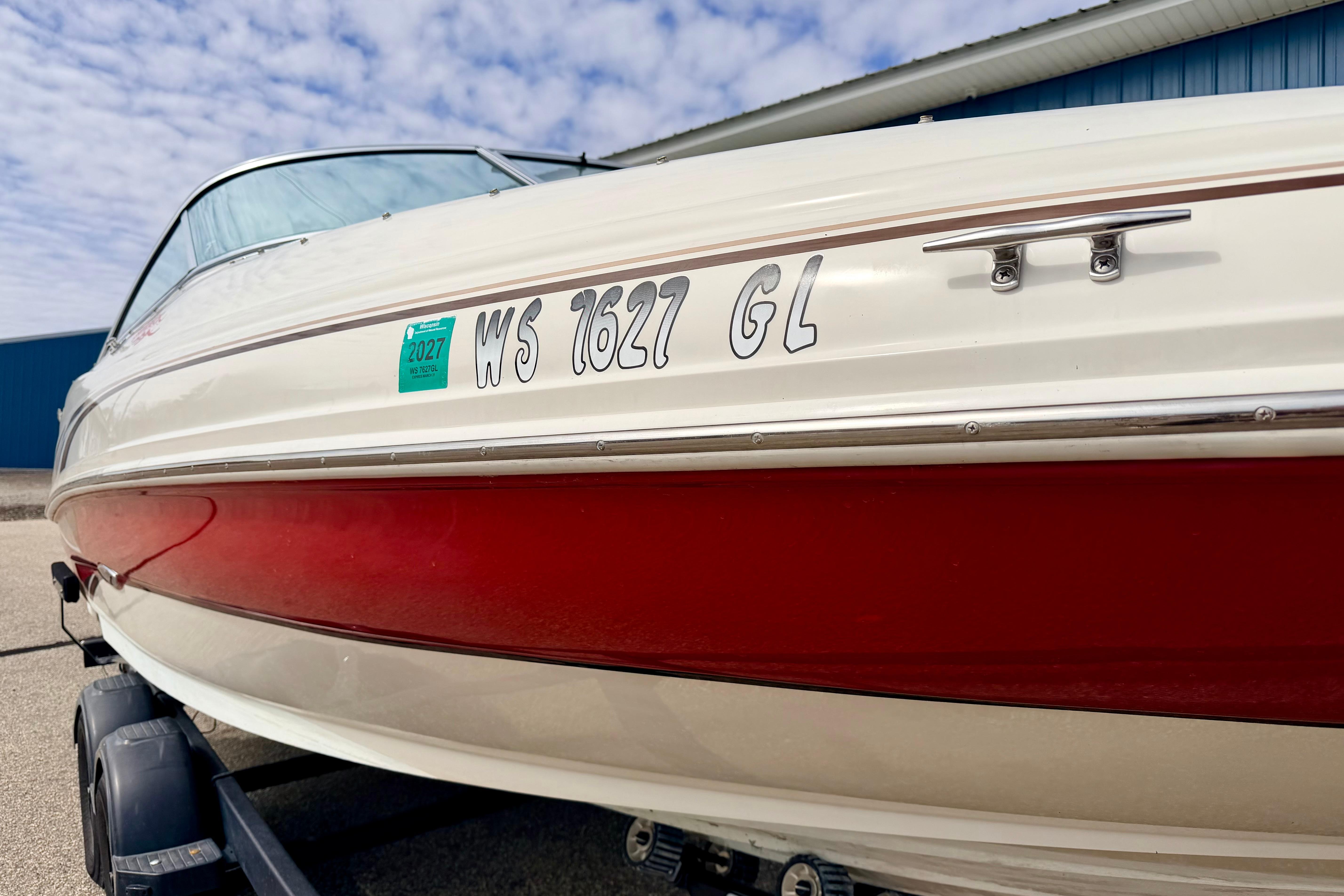 2003 Sea Ray 200 Sundeck boat with red and white hull on trailer.